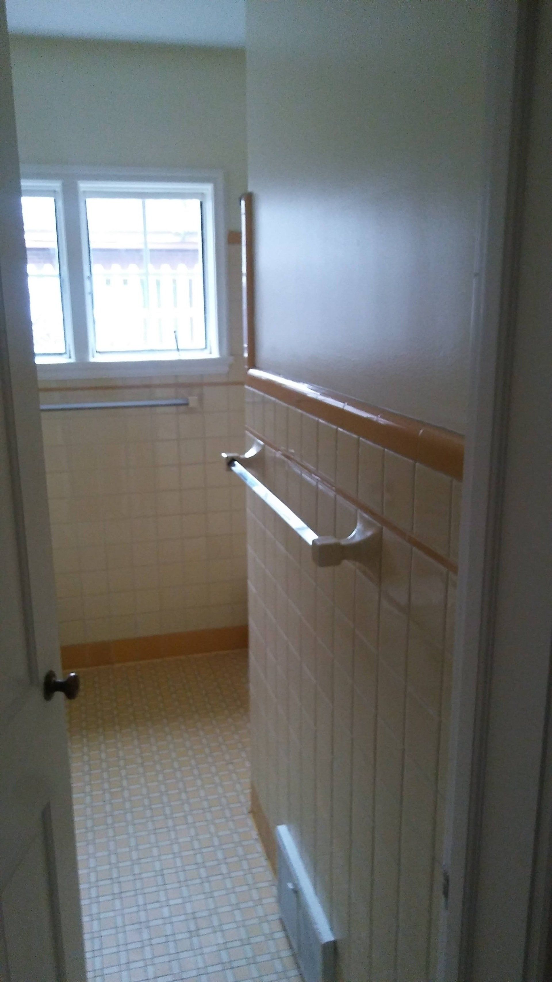 A bathroom with a towel rack and a window