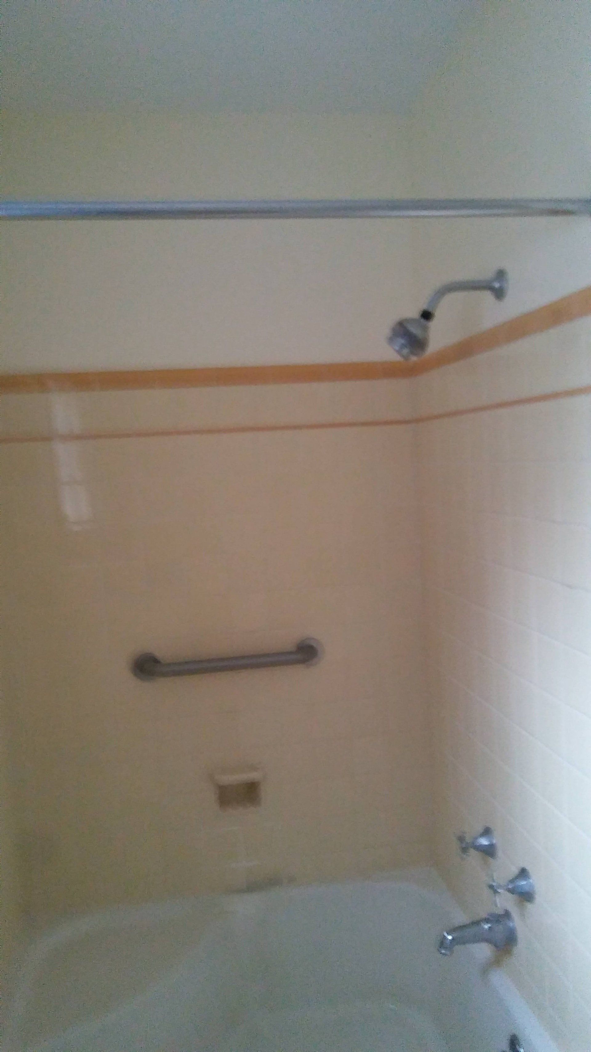 A bathroom with a bathtub and a shower head.