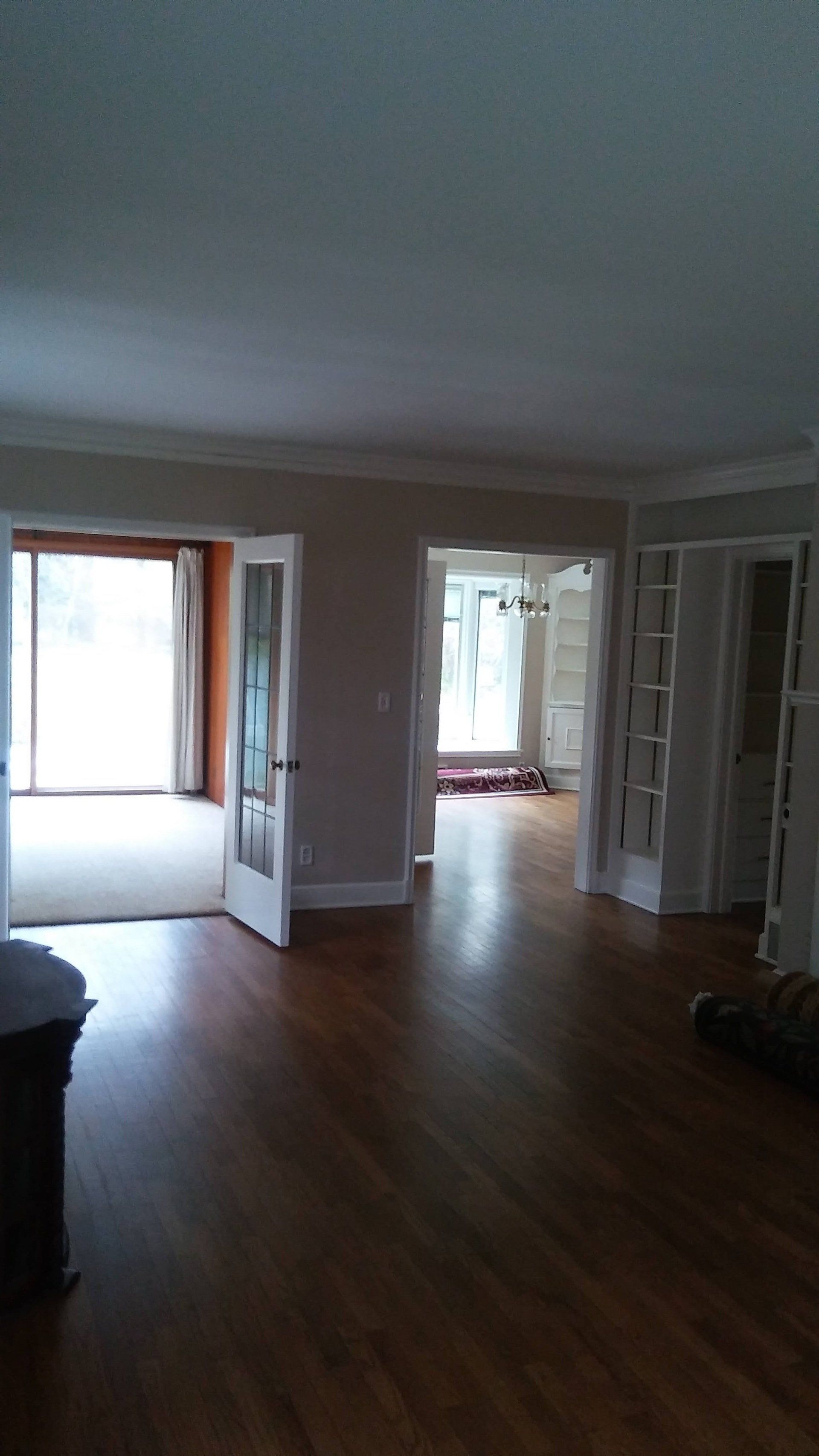 An empty living room with hardwood floors and french doors