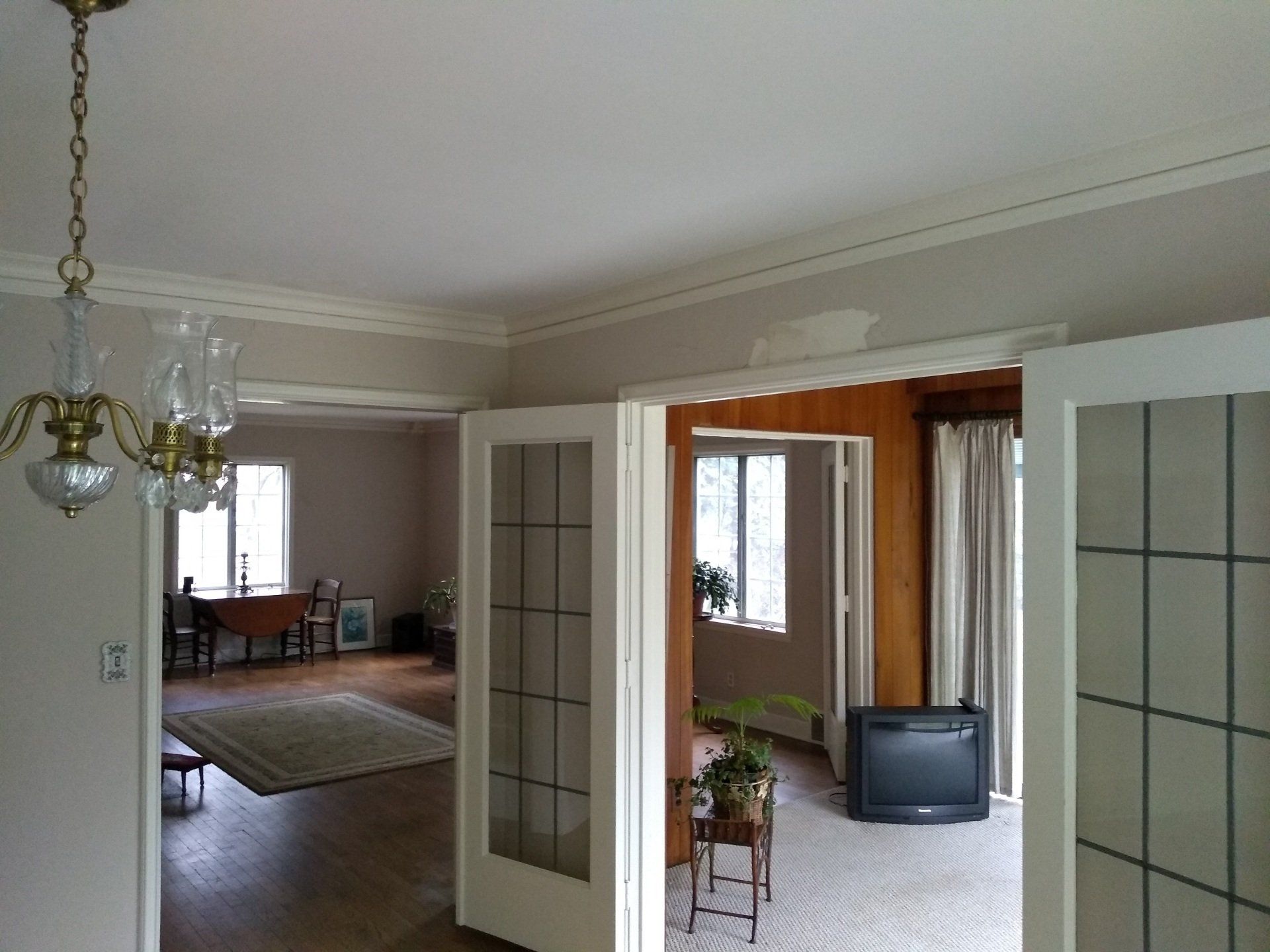 A living room with a television and a chandelier