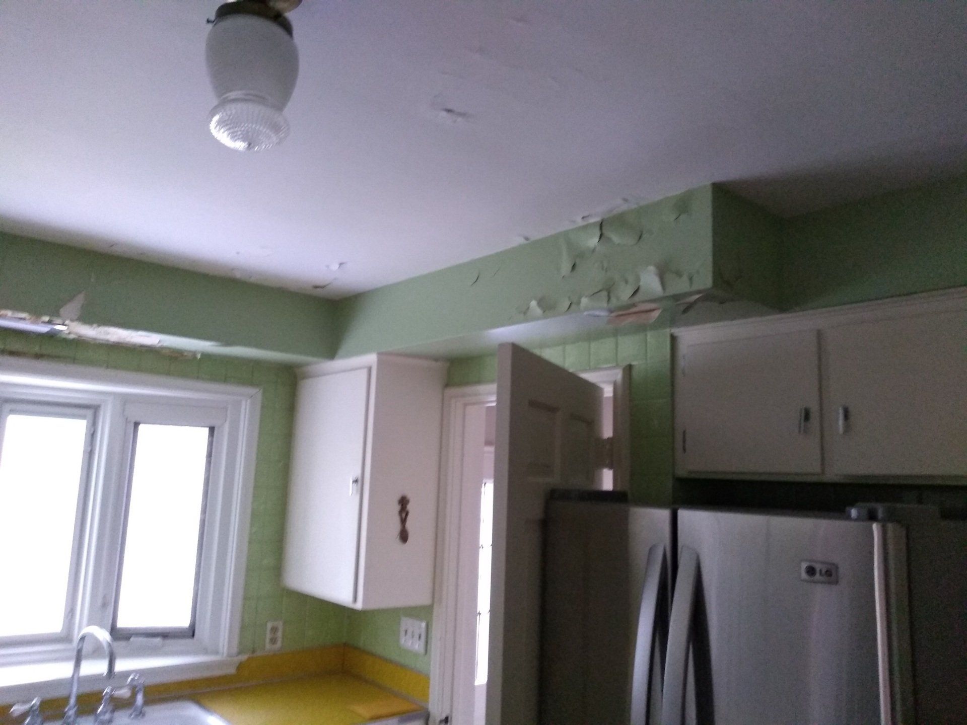 A kitchen with a stainless steel refrigerator and a sink