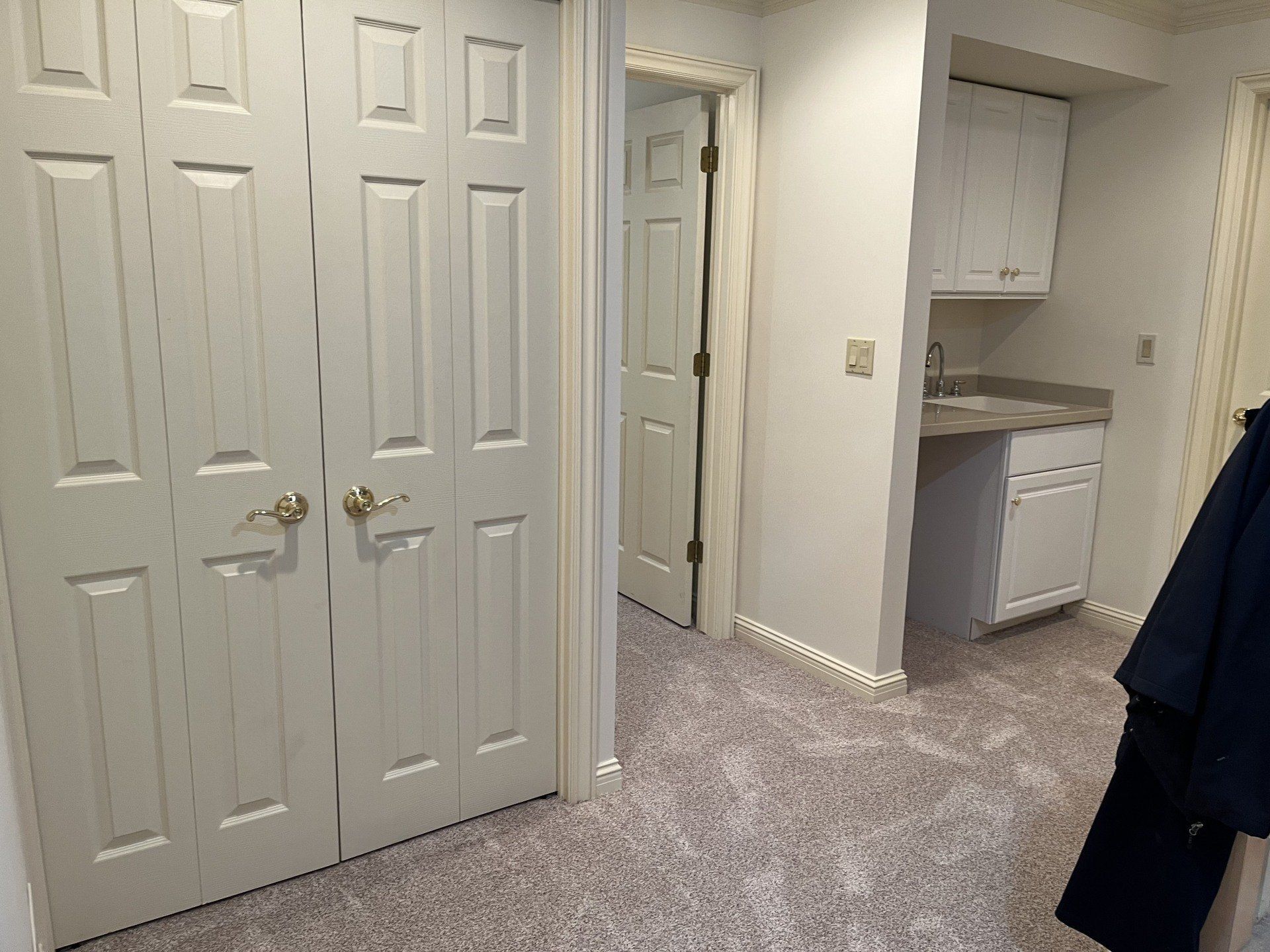 A room with a lot of doors and a sink in it