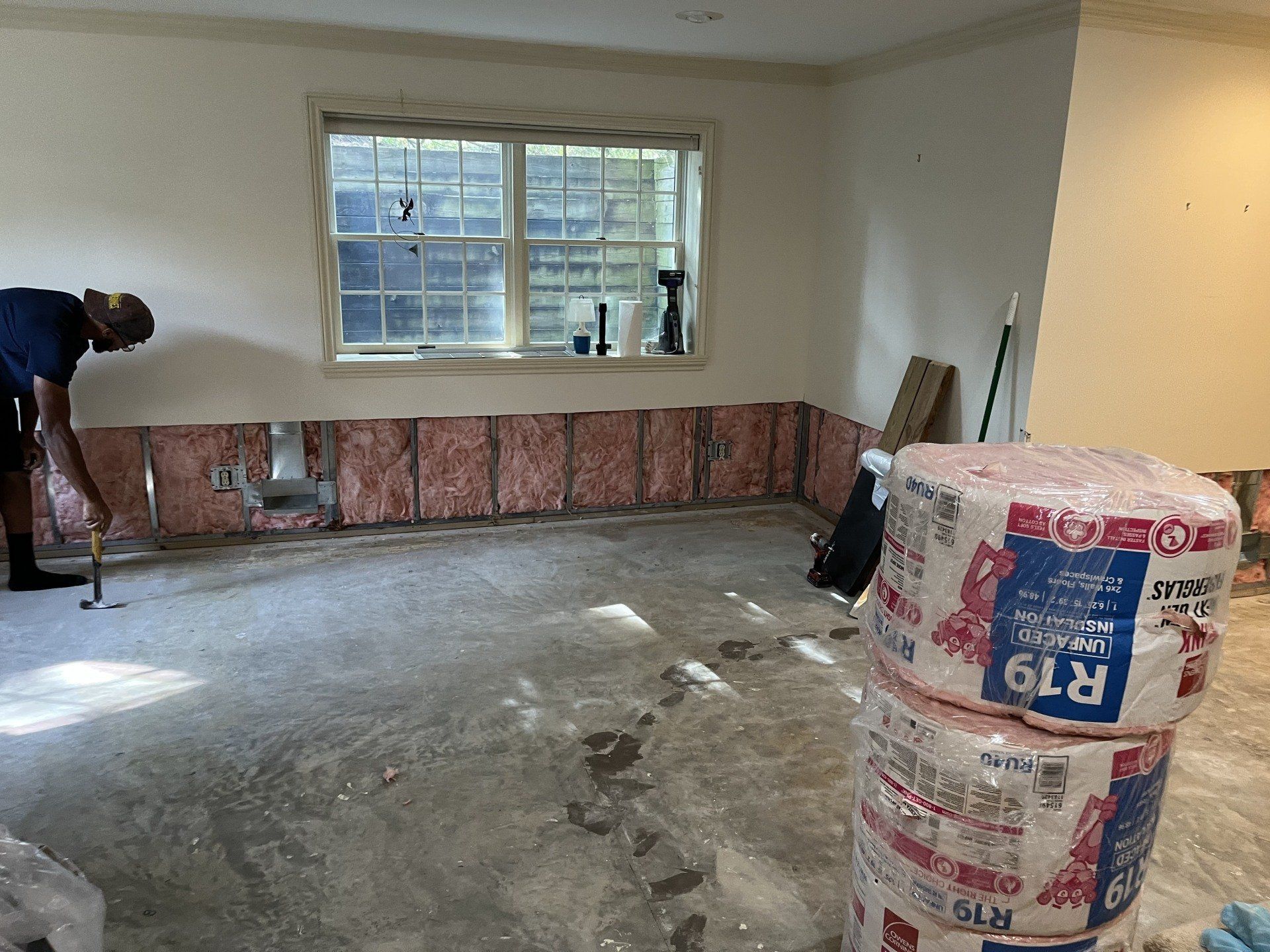 A man is working on a wall in a room.