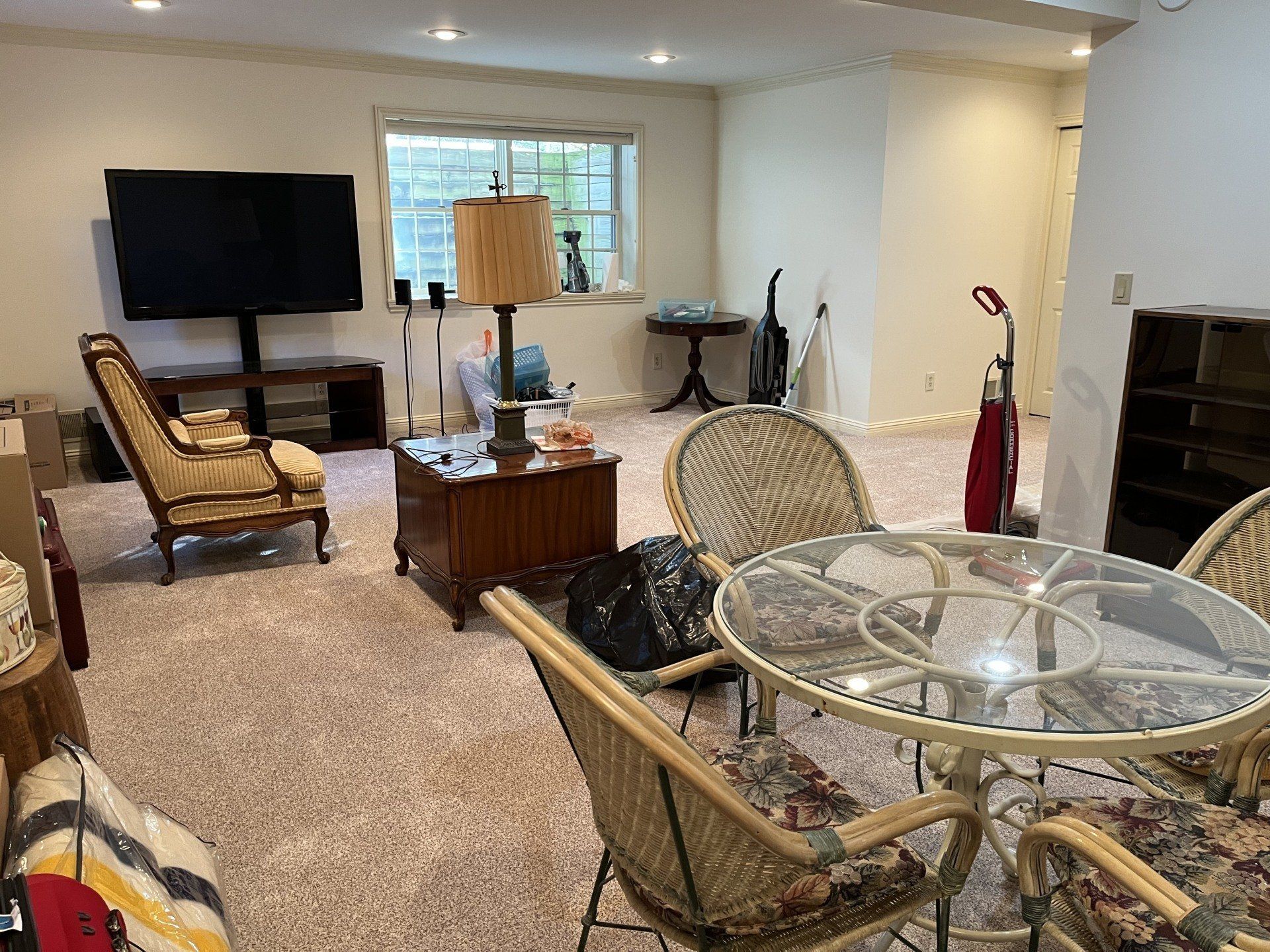 A living room with a table and chairs and a flat screen tv.