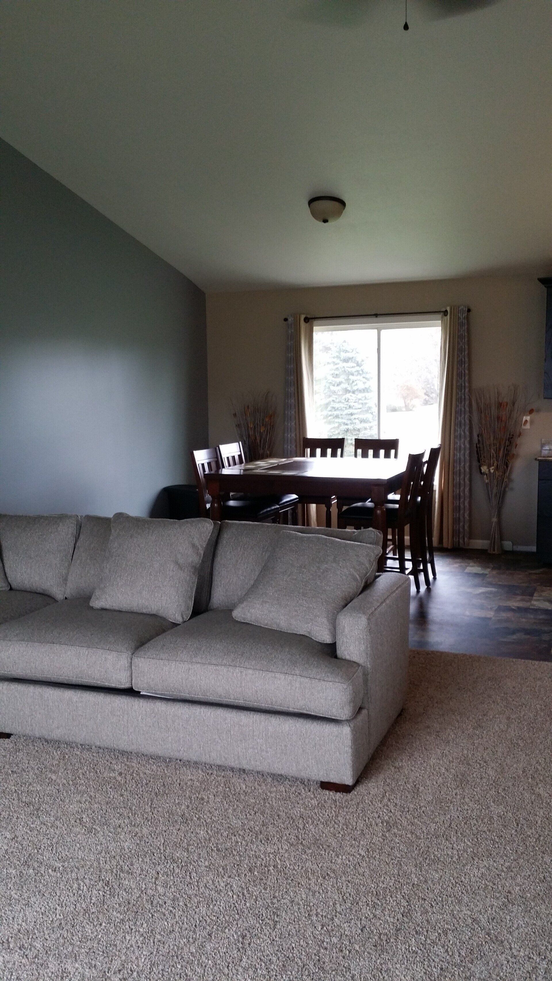 A living room with a couch , table and chairs.