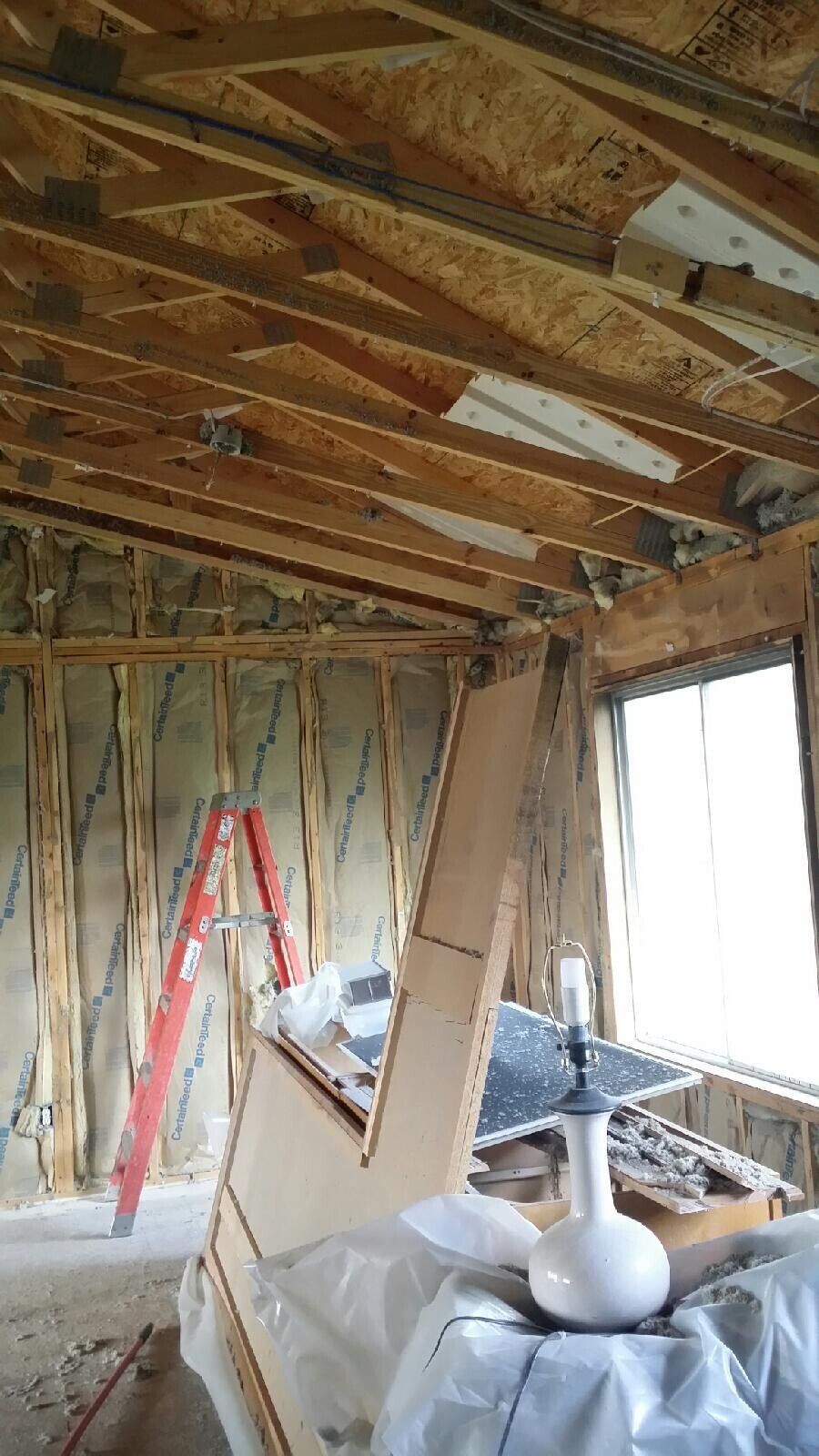 A room with a ladder and a lamp in it.