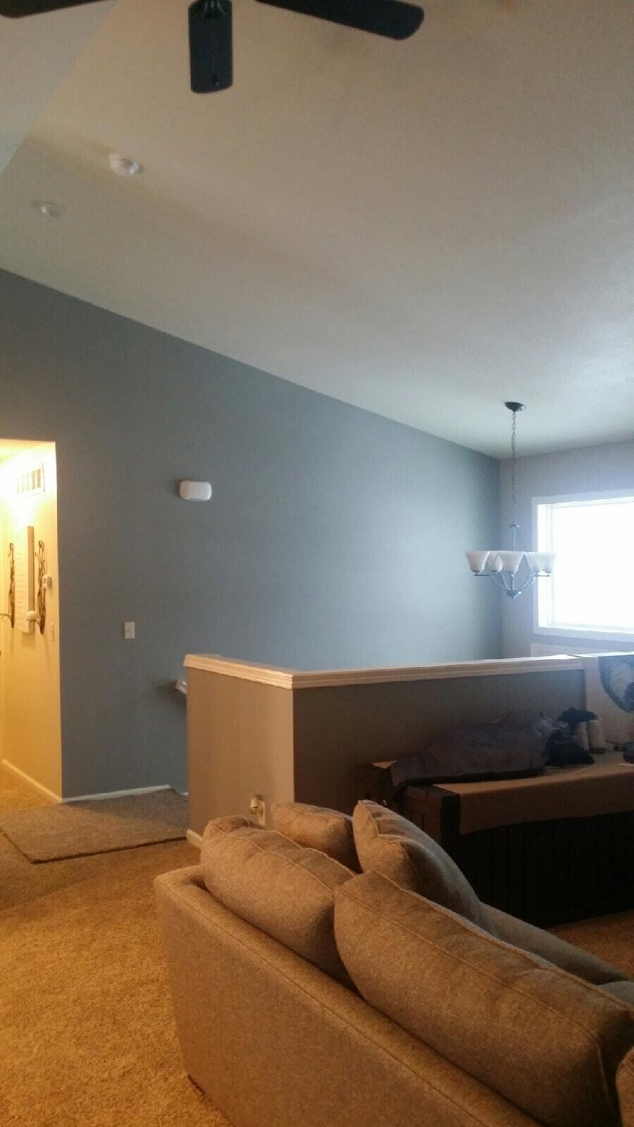 A living room with a couch and a ceiling fan.