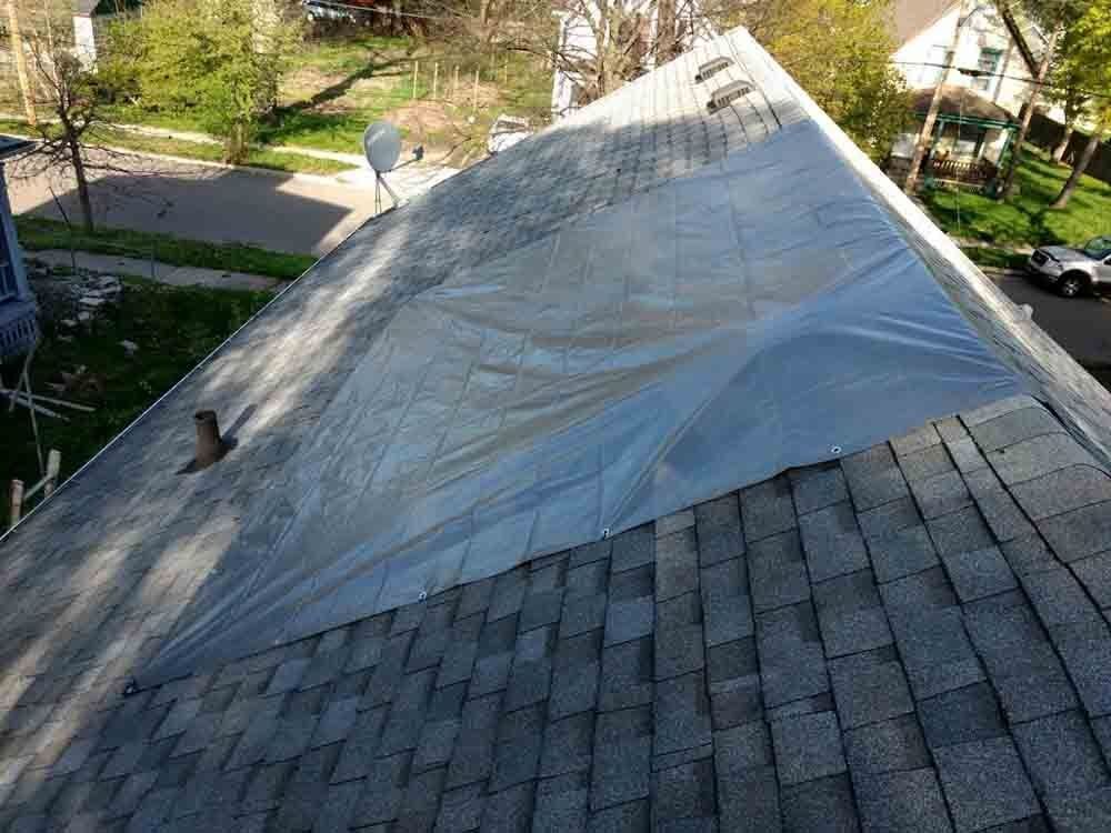 The roof of a house is covered in plastic.