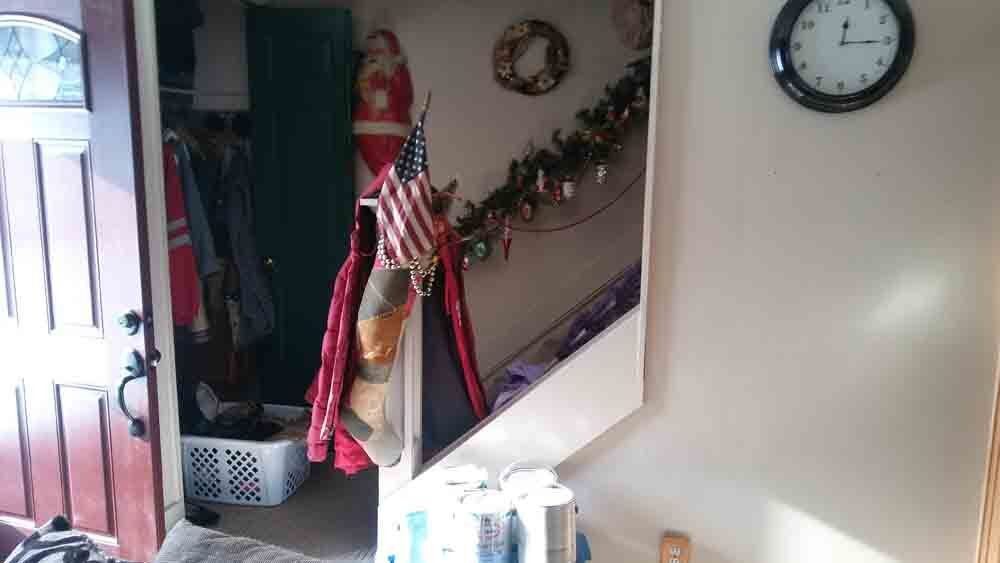 A room with a clock on the wall and stairs.