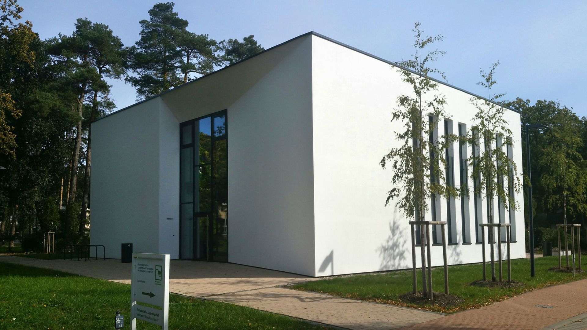 Ein großes weißes Gebäude mit Bäumen davor
