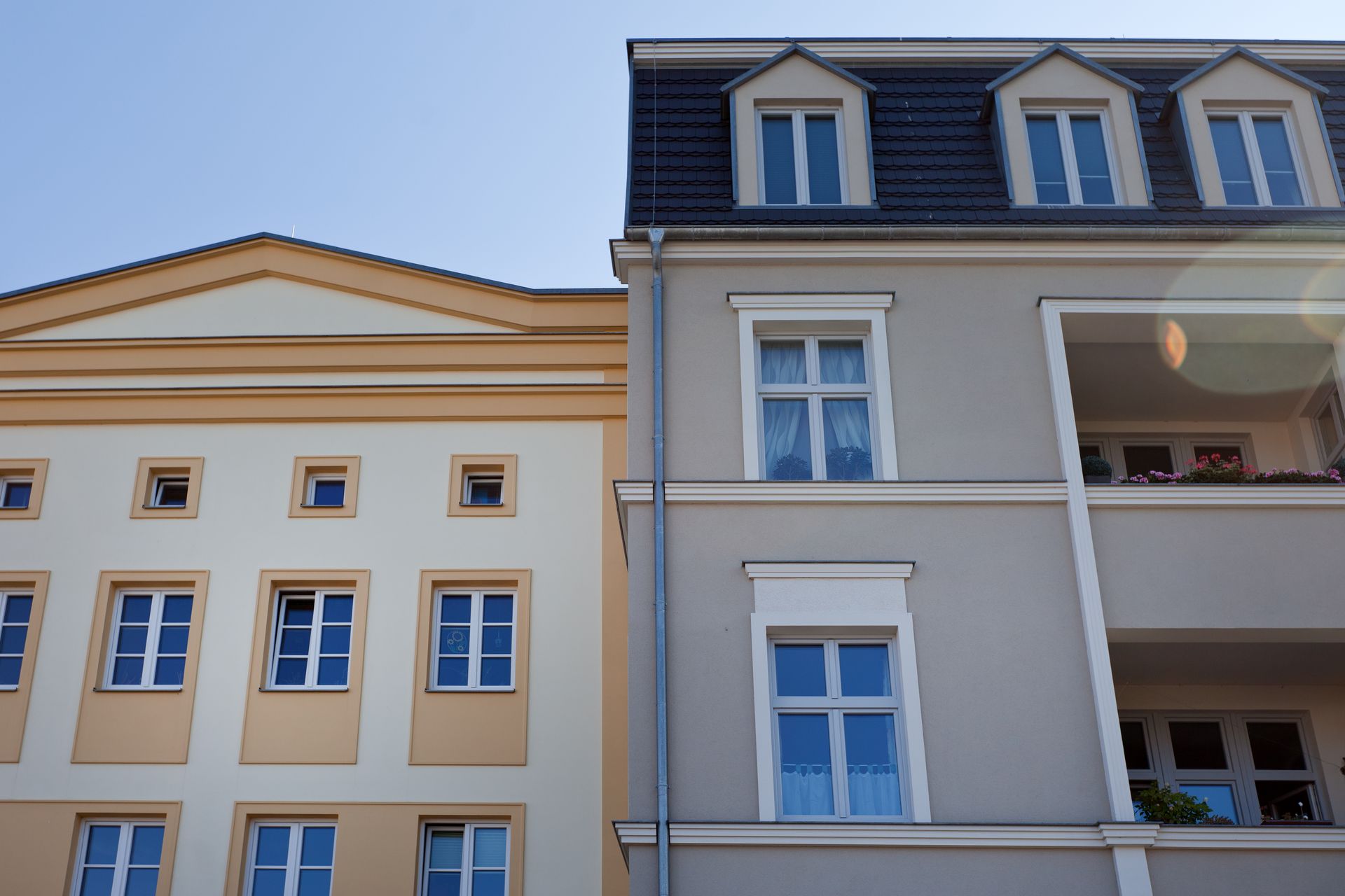 Zwei nebeneinander liegende Gebäude, eines davon mit Balkon