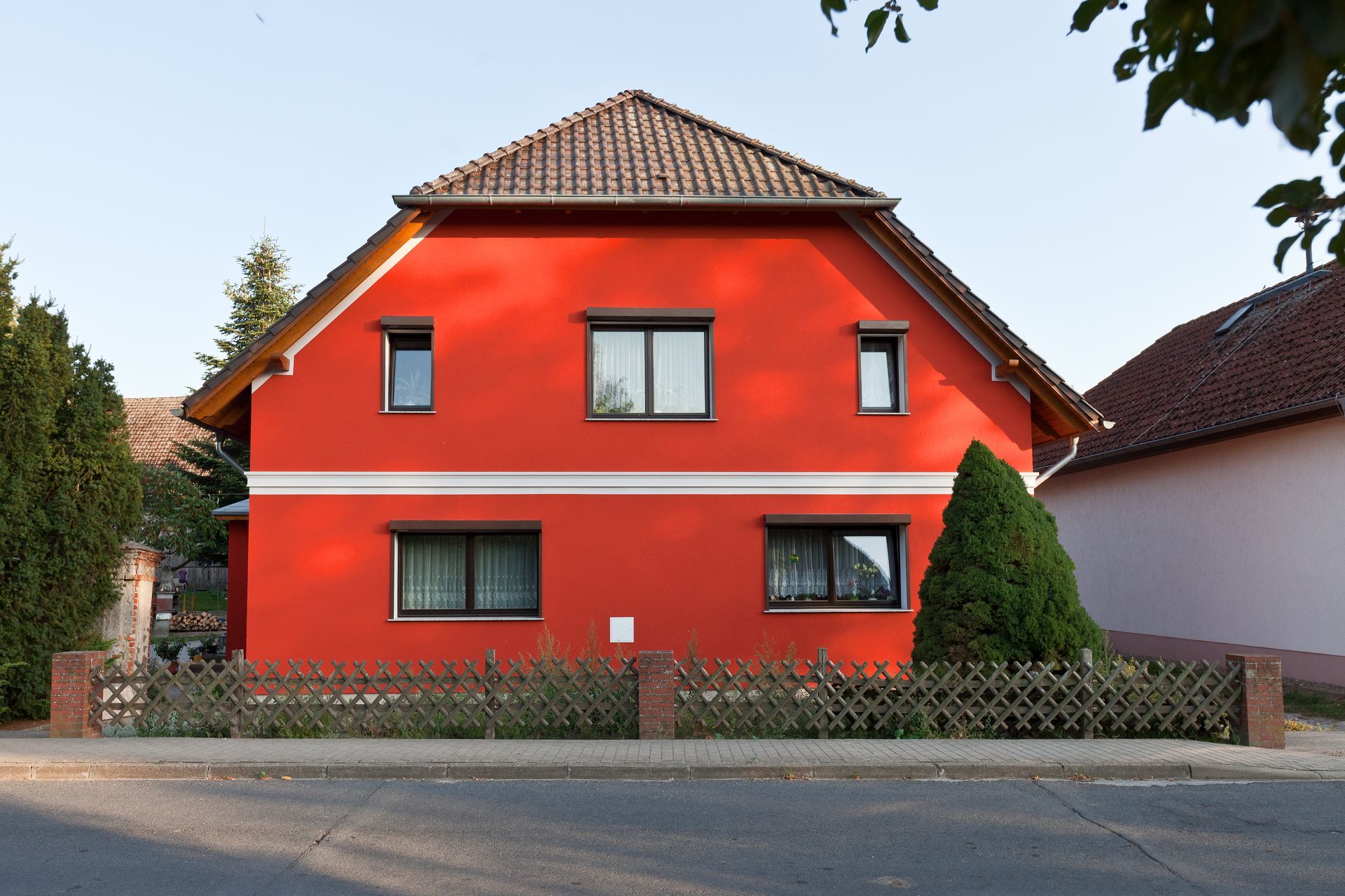 Ein rotes Haus mit einem Zaun davor