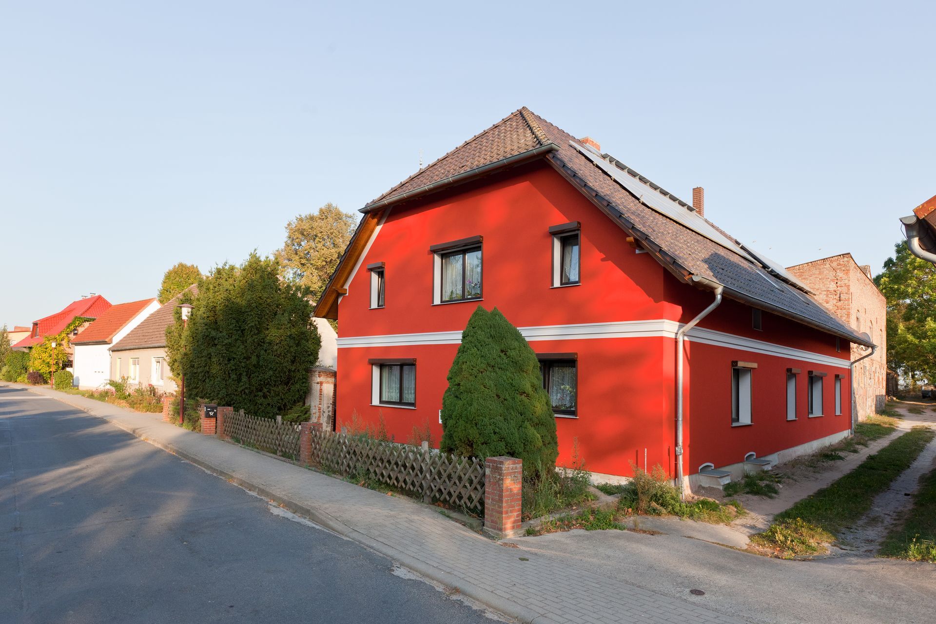 Ein rotes Haus steht an der Ecke einer Straße