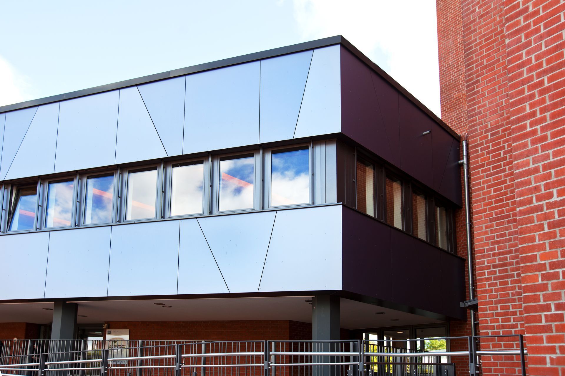 Blick auf eine Gebäudeecke mit vorgehängter hinterlüfteter Fassade. Fassadenplatten in Metalloptik.