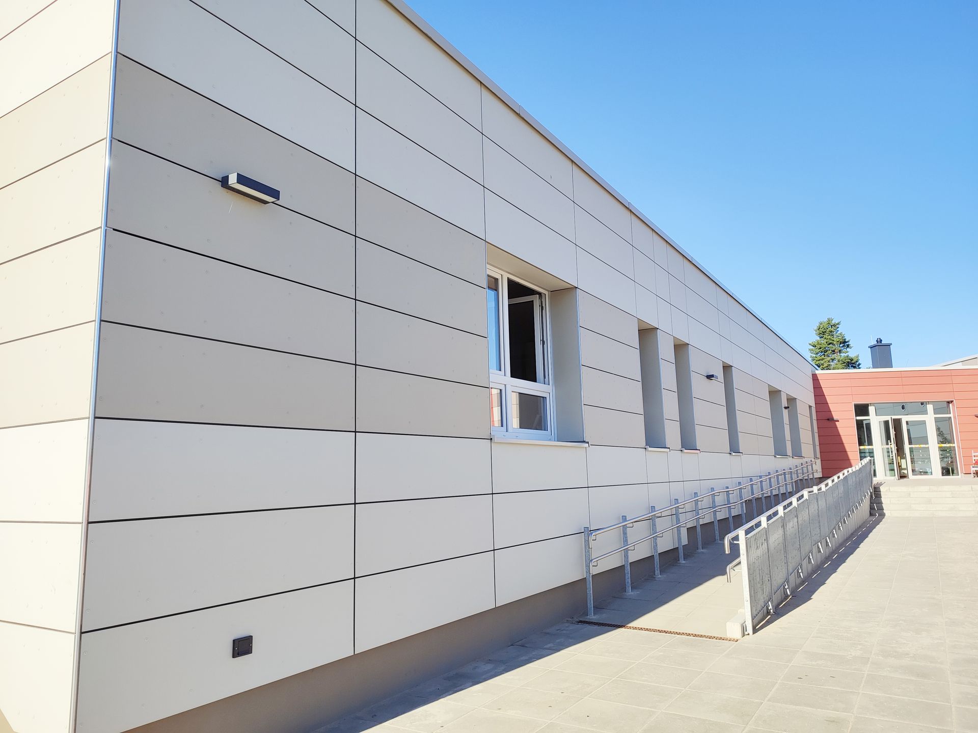 Eine Gebaeudewand mit Gelaender und Rampe davor