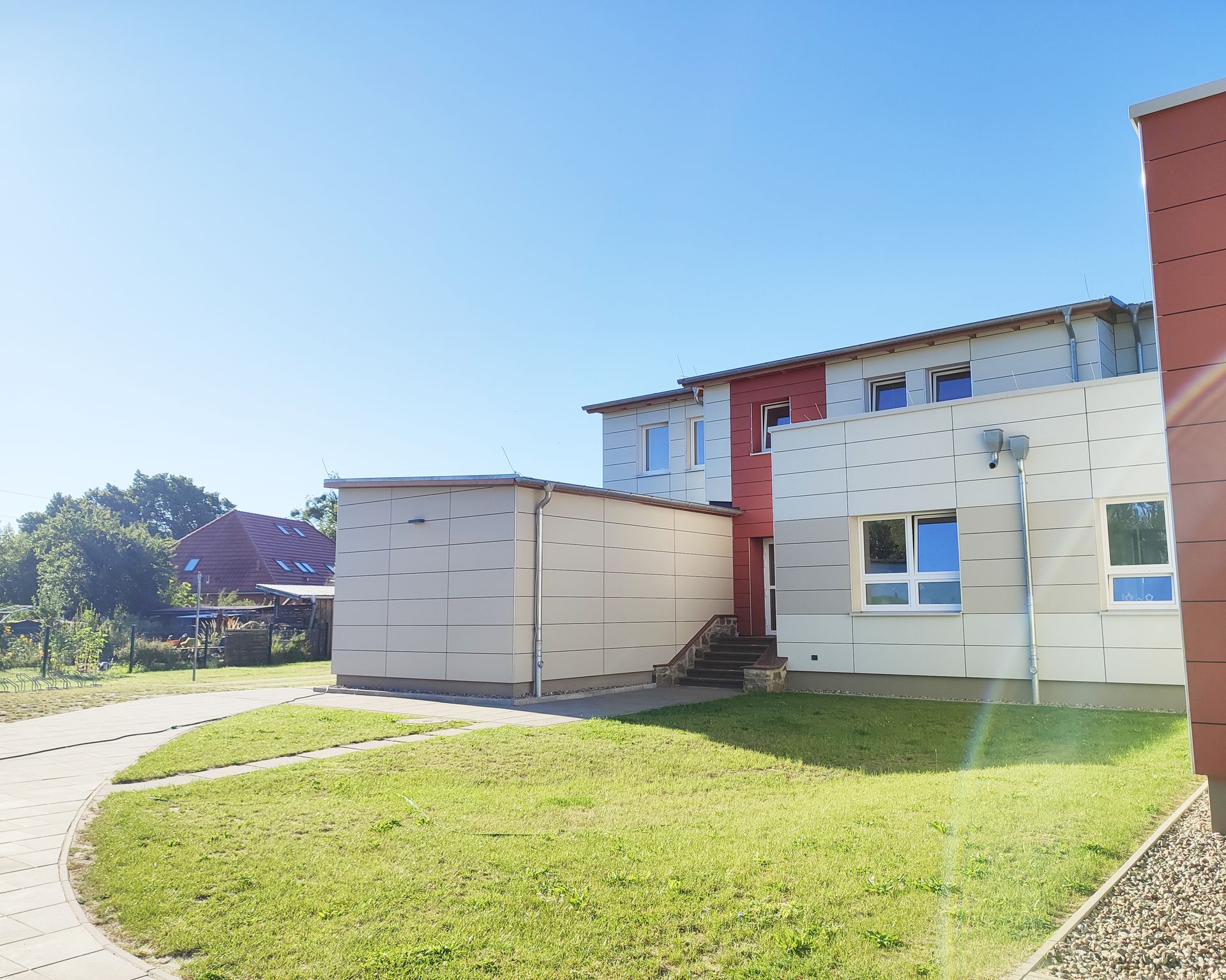 Eine Gebaeudeecke mit Wiese davor