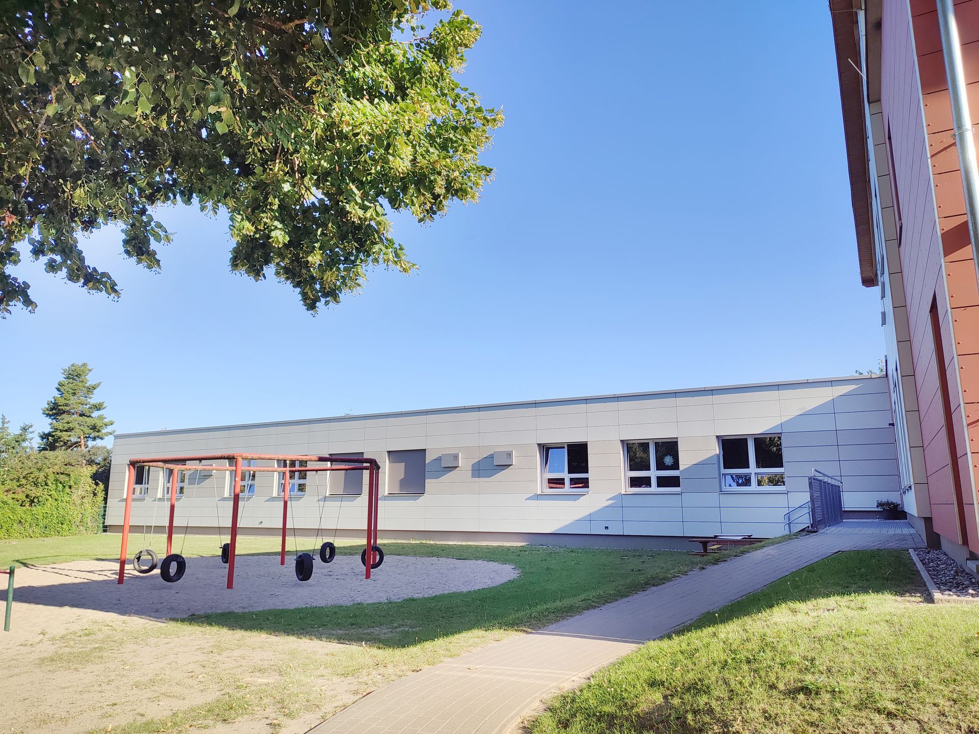 Ein Kita-Hof mit Spielgeraet davor