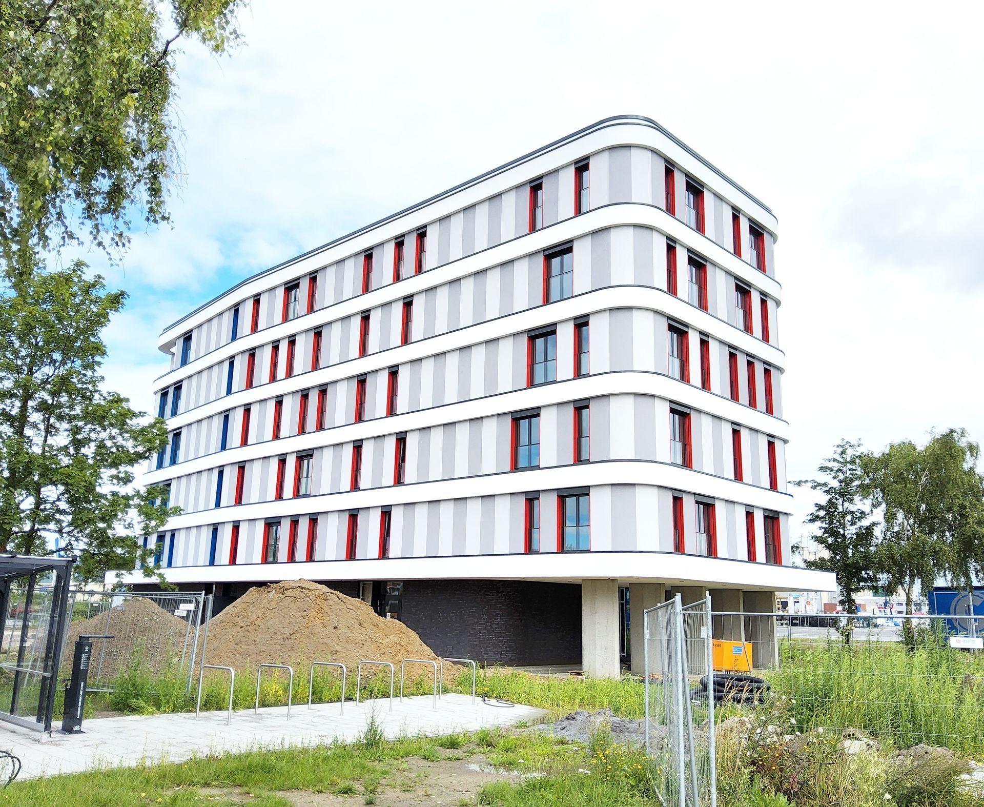 Ein großes modernes Gebäude mit weißen, grauen, roten und blauen Fassadenelementen