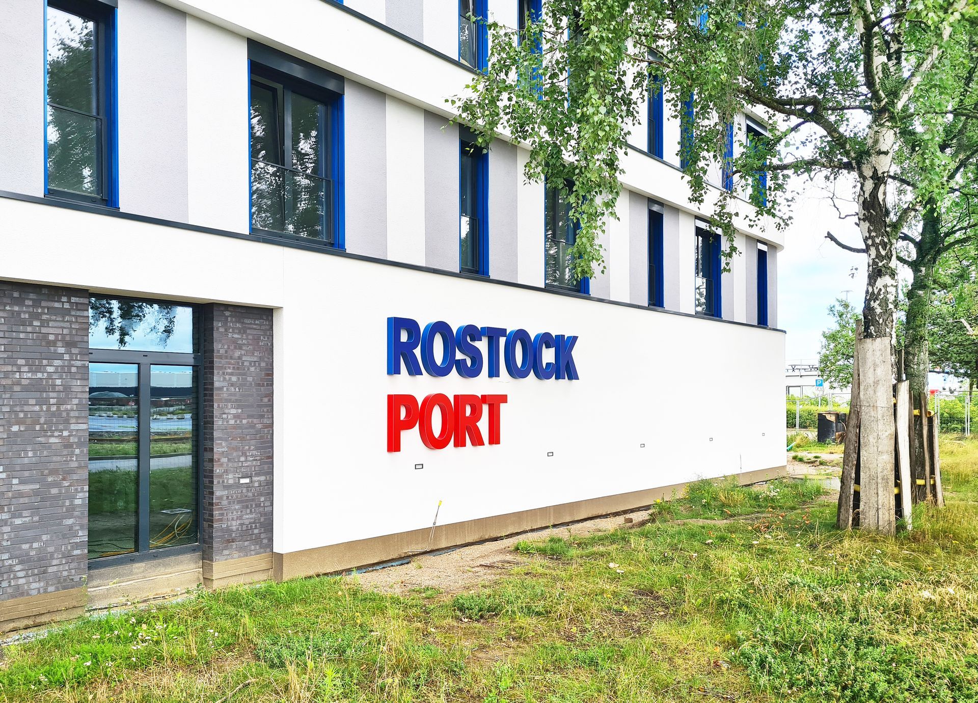 Ein blau-roter Schriftzug am Gebäude  - Rostock Port