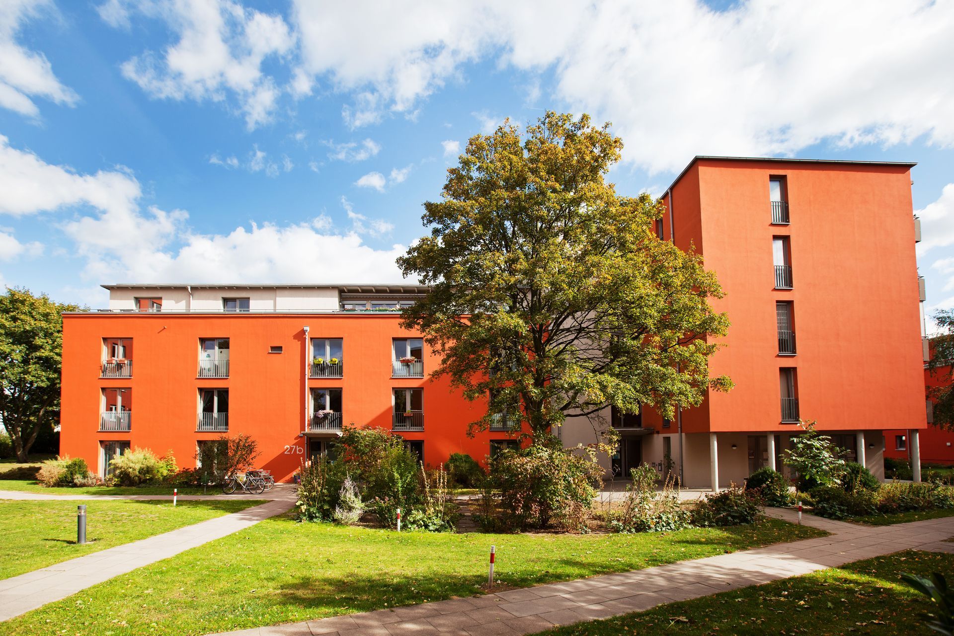 Ein großes orangefarbenes Gebäude mit einem Baum davor