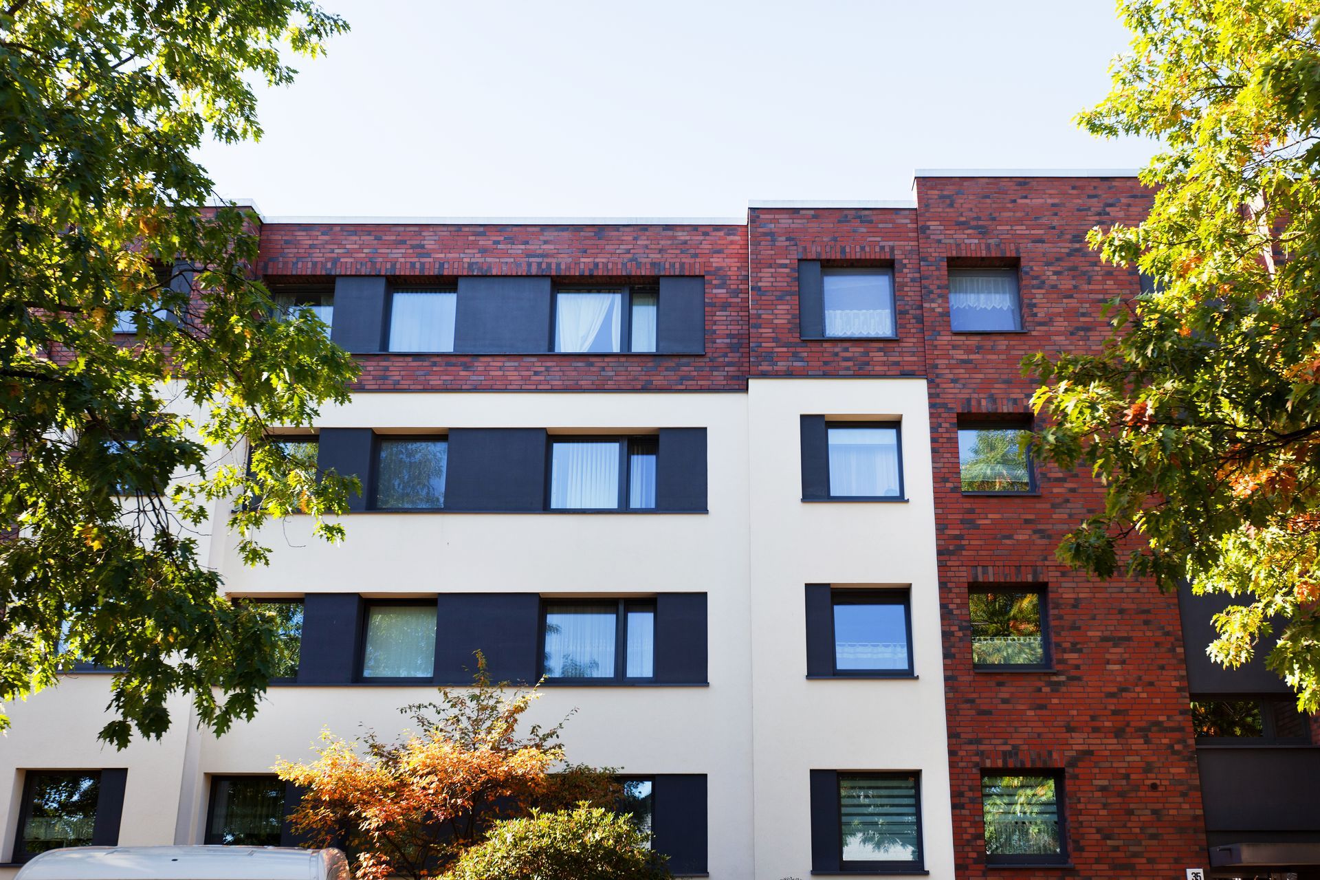 Ein Gebäude mit vielen Fenstern und einem Baum davor