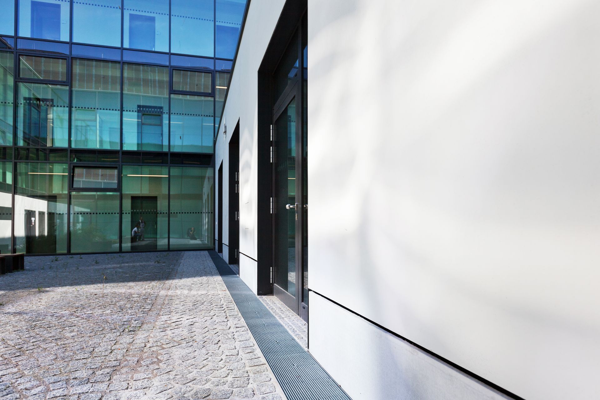 Eine weiße Wand mit Tür und Blick auf eine Glasfront