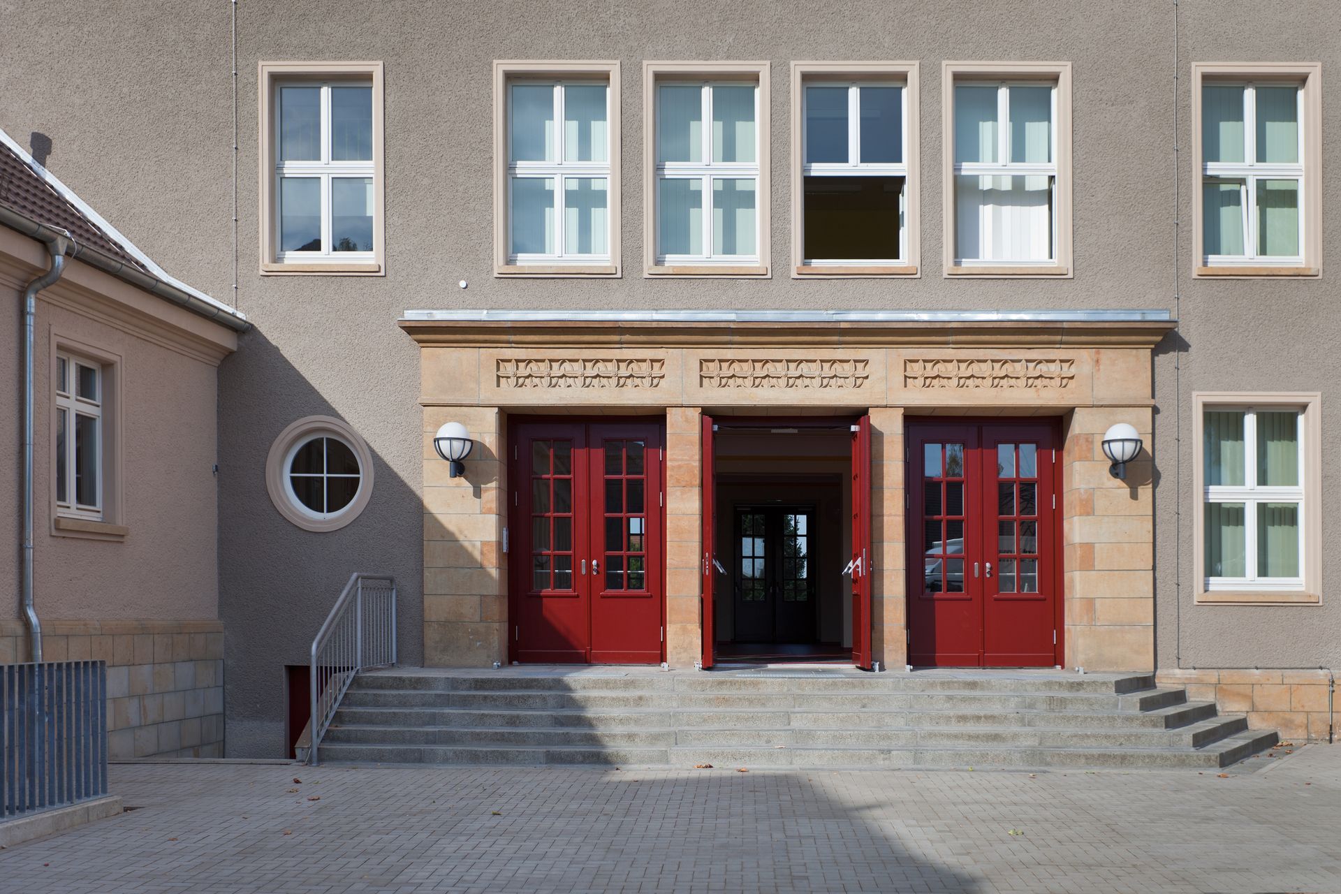 Die Vorderseite eines Gebäudes mit roten Türen und Treppen