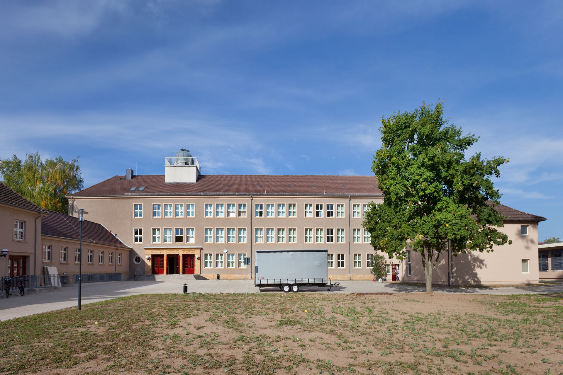 Ein großes Gebäude mit einem davor geparkten Anhänger