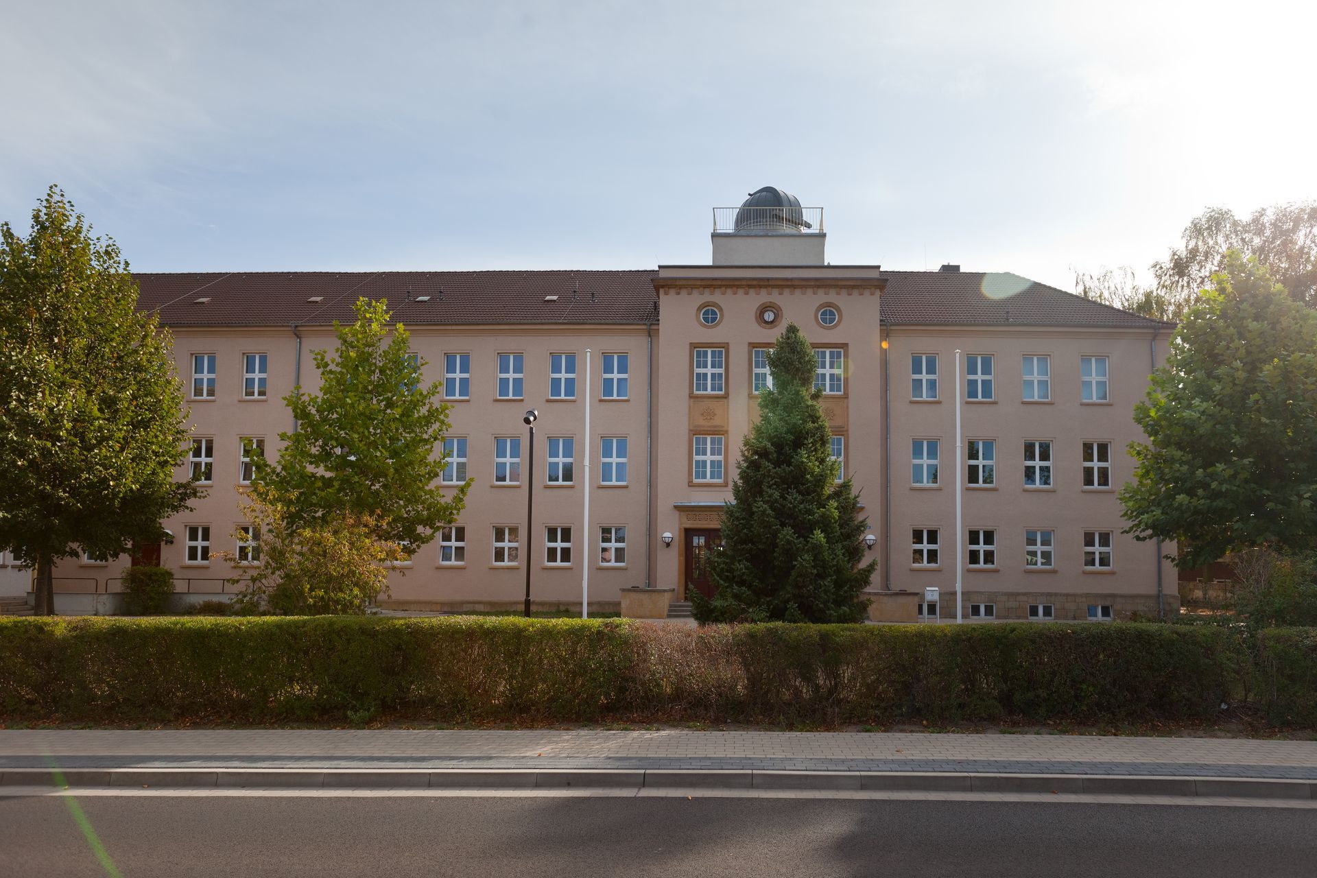 Ein großes Gebäude mit vielen Fenstern und Bäumen davor