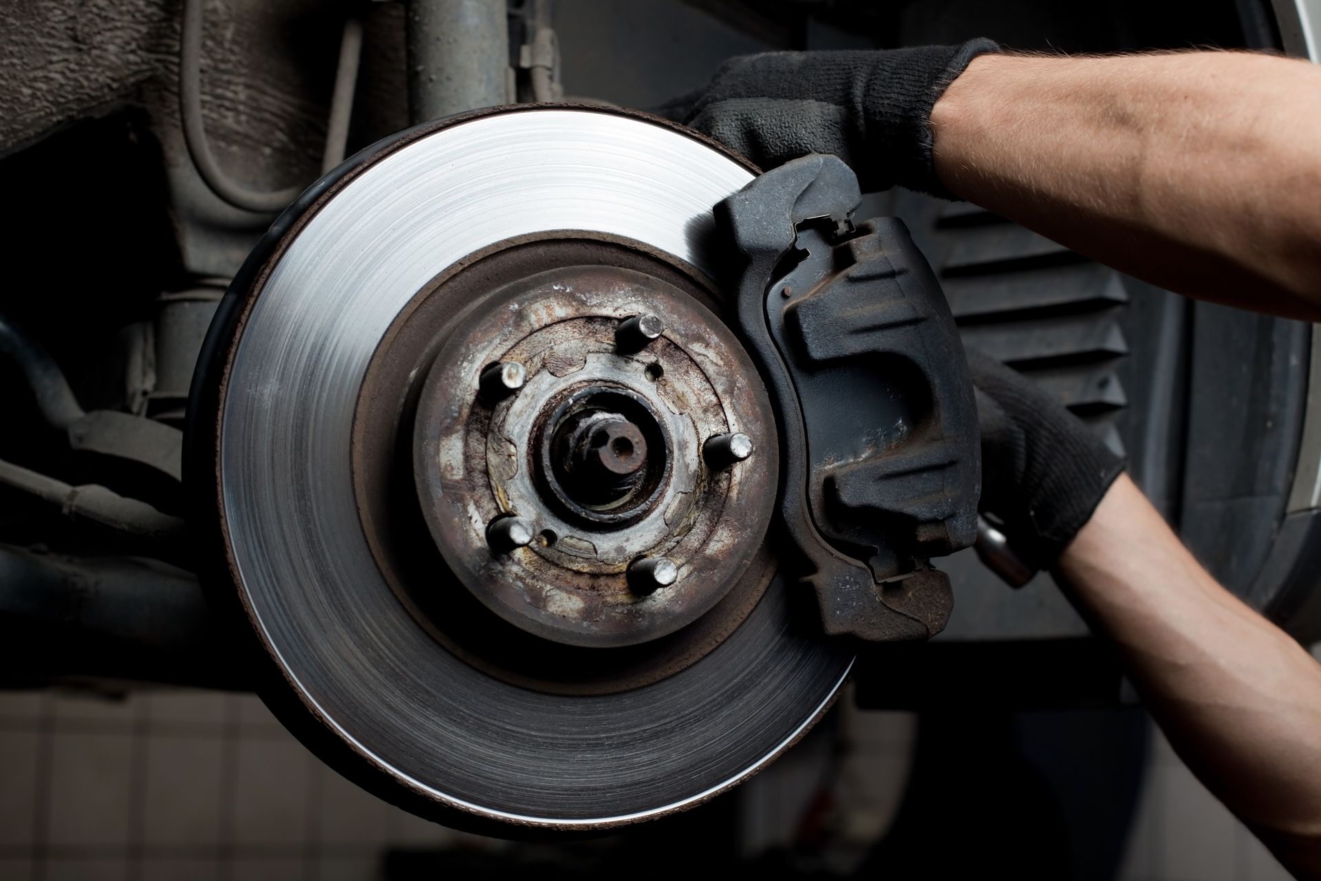 Close-up of a mechanic performing an auto brake service, repairing brake pads.