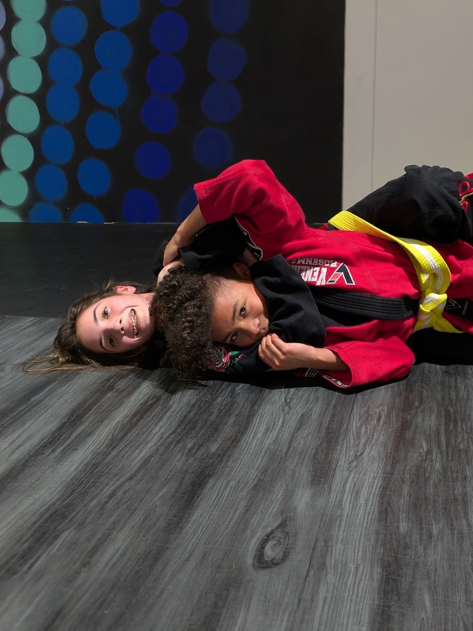 A boy and a girl are practicing martial arts on the floor