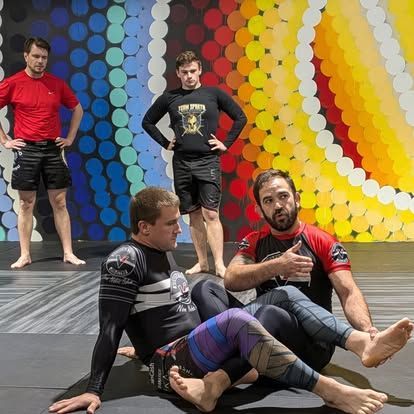 A group of men are posing for a picture in front of a colorful wall