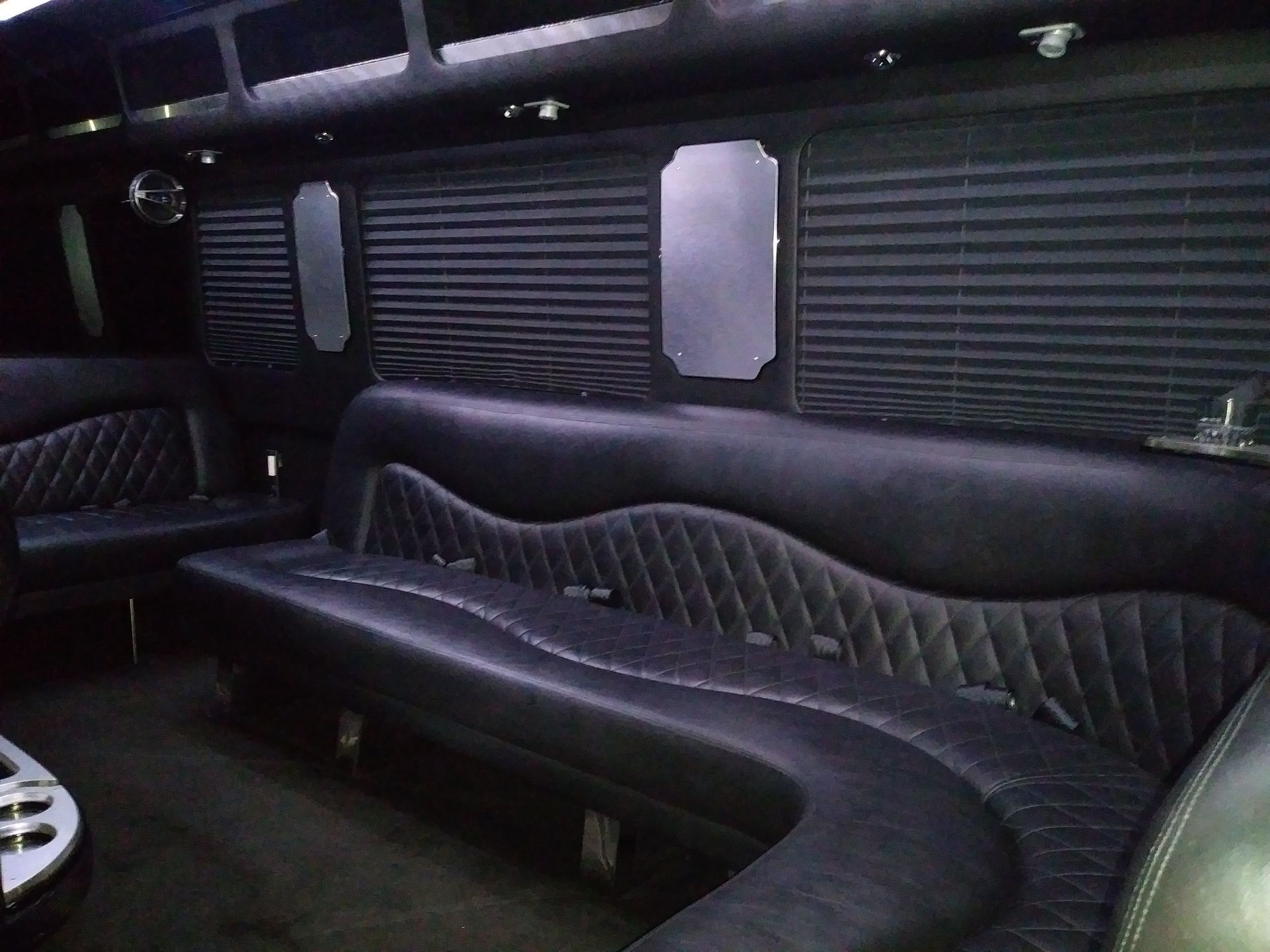 The inside of a limousine with a long black couch