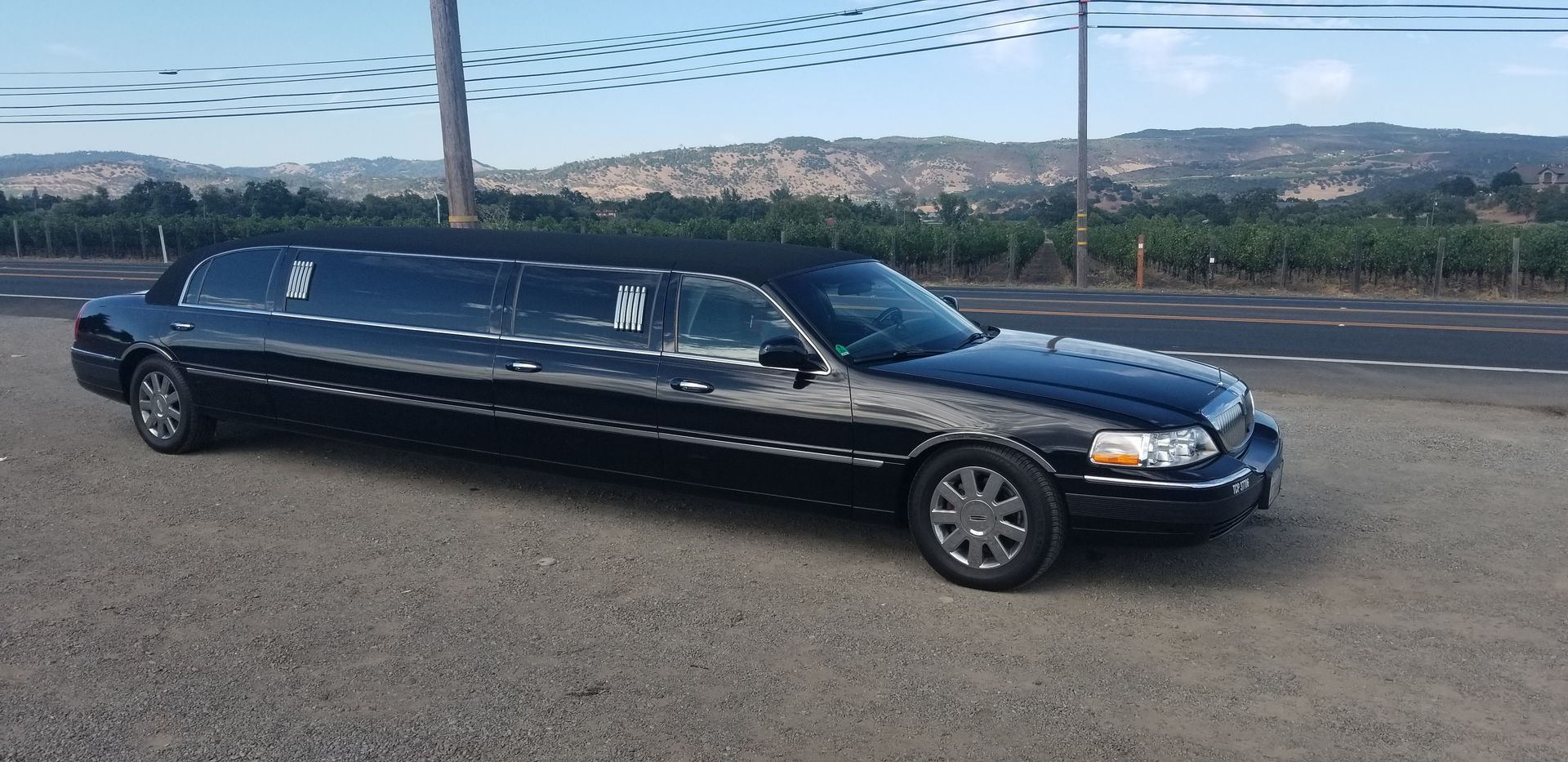 A black limousine is parked on the side of the road.