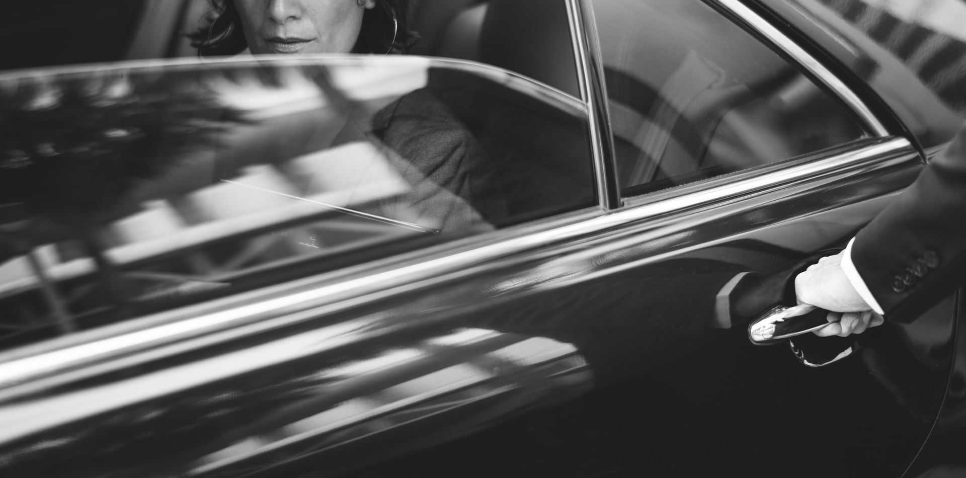 A man in a suit is getting out of a car.