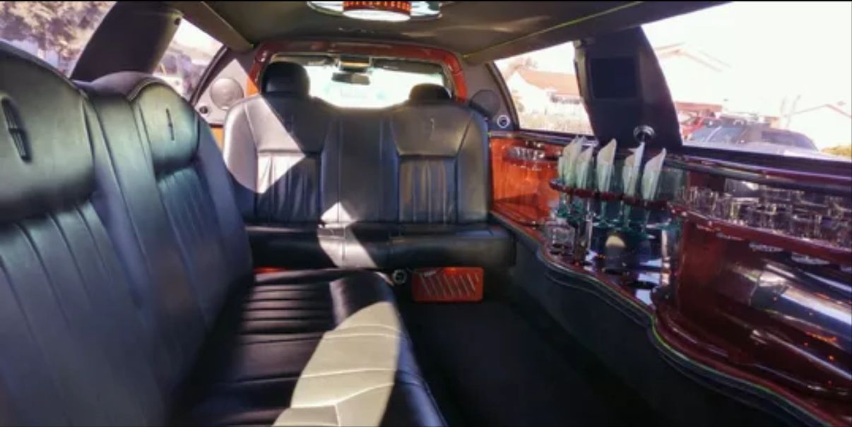 The inside of a limousine with a lot of seats and a bar.