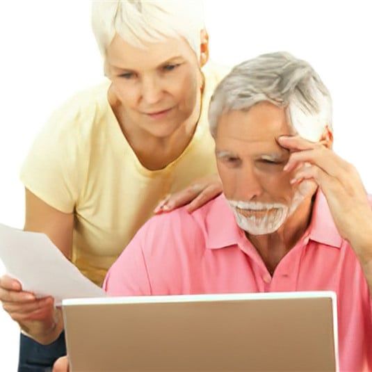 A man and a woman are looking at a laptop together.