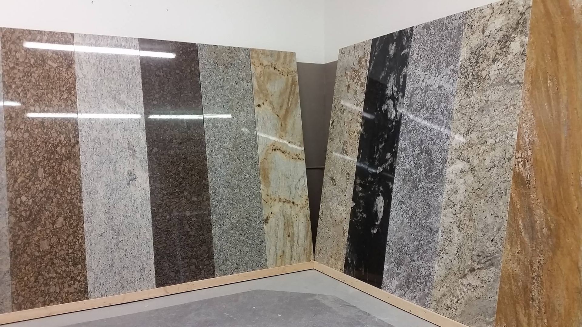 Stone slabs, various colors and patterns, displayed in a showroom.