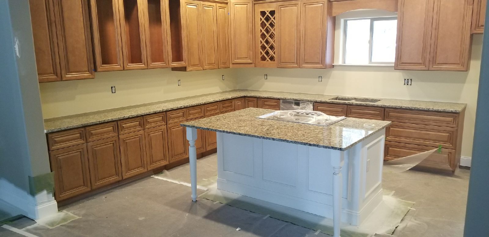 Kitchen with light wood cabinets, granite countertops, and a white island.