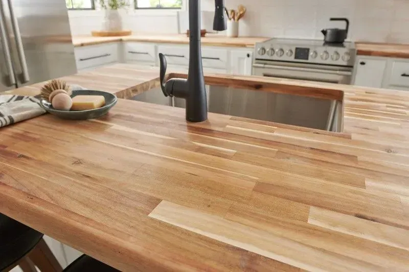 Wooden kitchen countertop with built-in sink and black faucet.