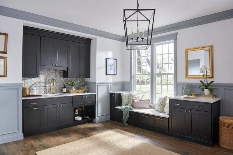 Dark gray kitchen with white walls, window seat, and wood floors.
