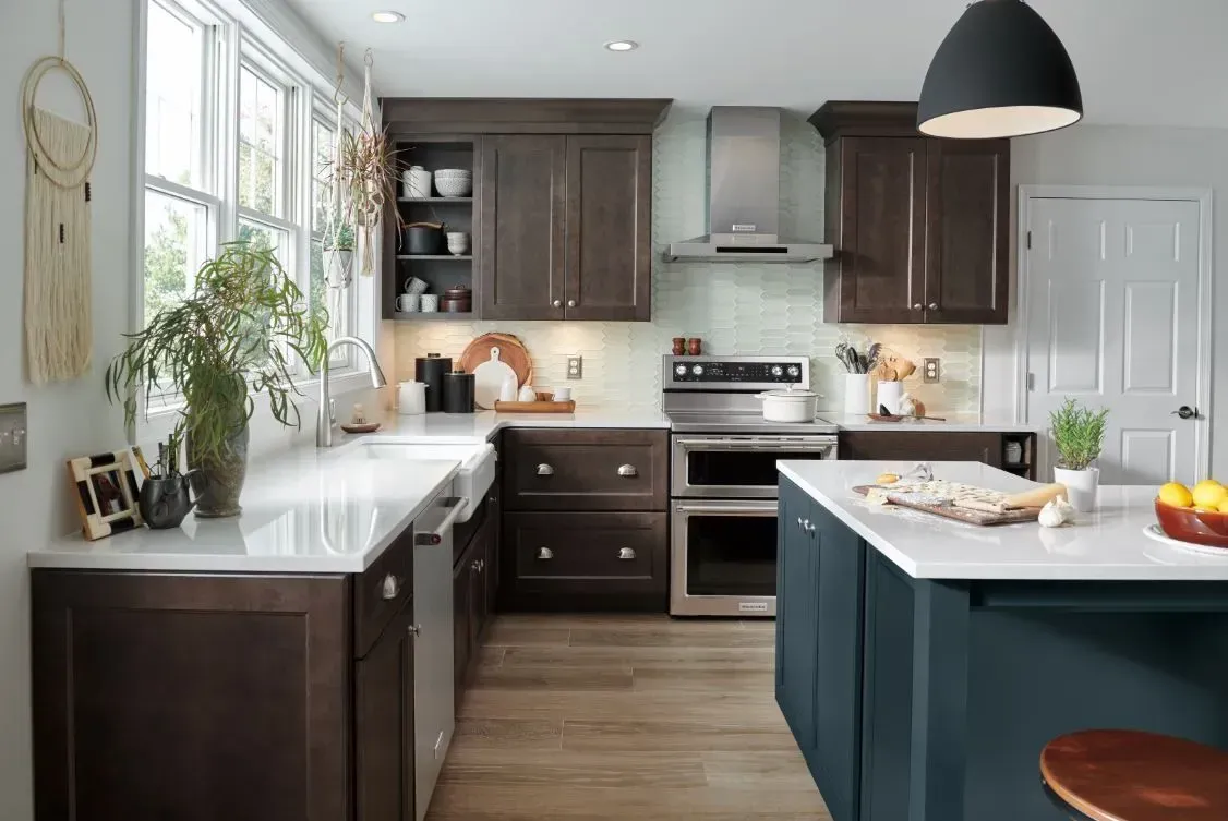 U-shaped kitchen with dark brown cabinets, white countertops, stainless steel appliances, and a blue island.