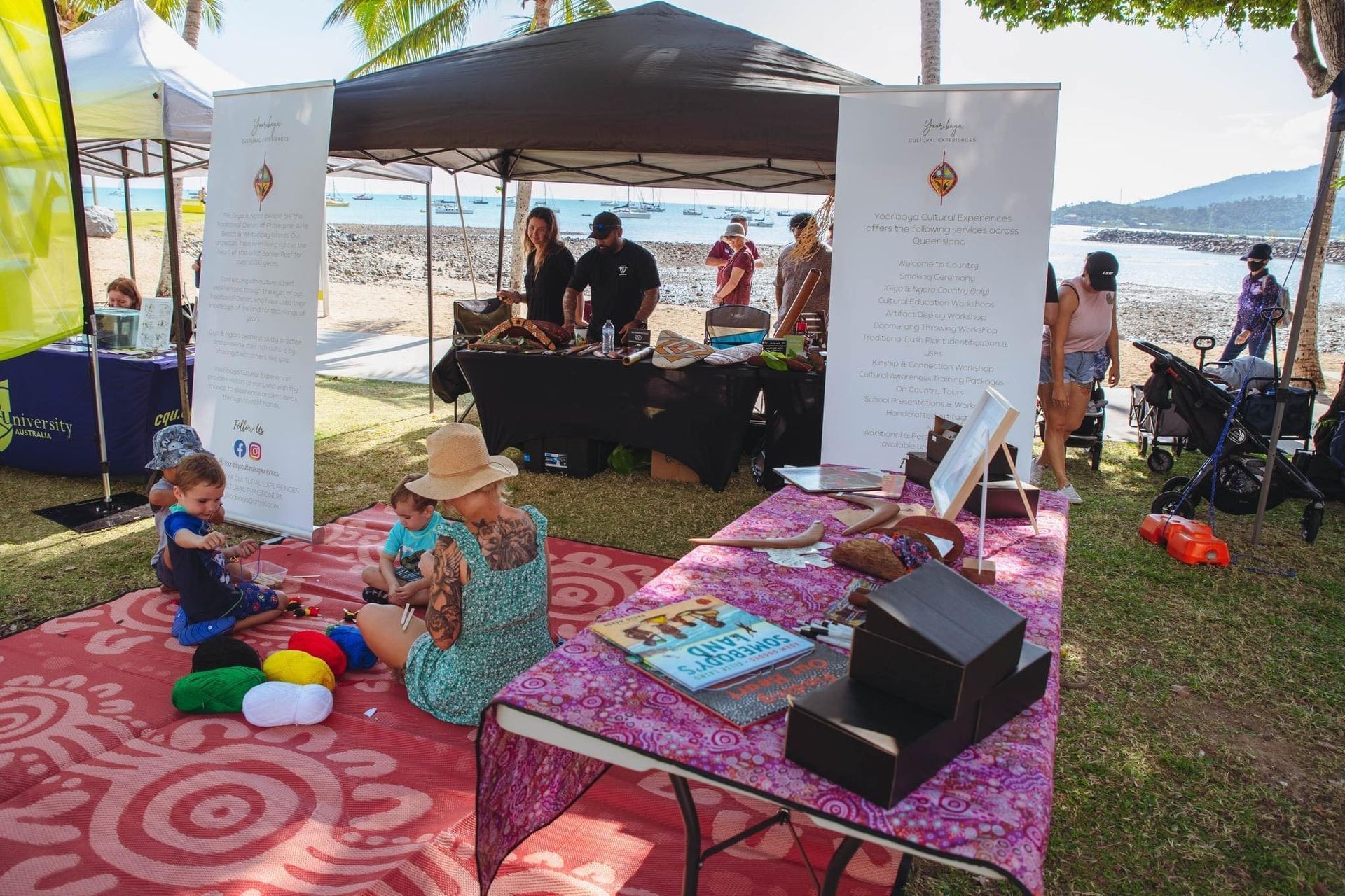 A group of people are sitting around a table in a park.