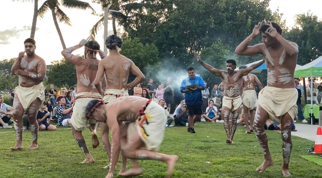 A group of men are dancing in a field.