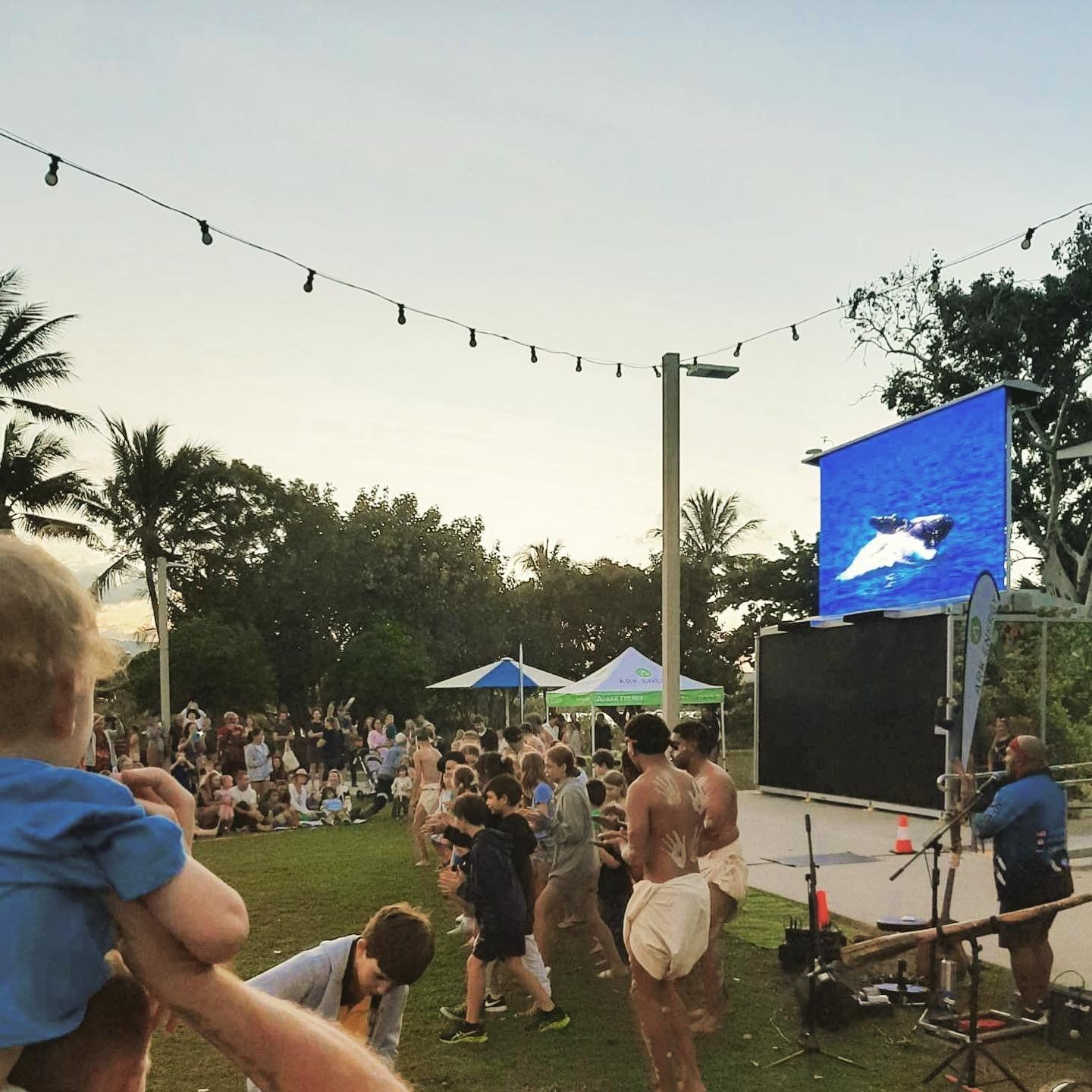 A group of people standing in front of a large screen