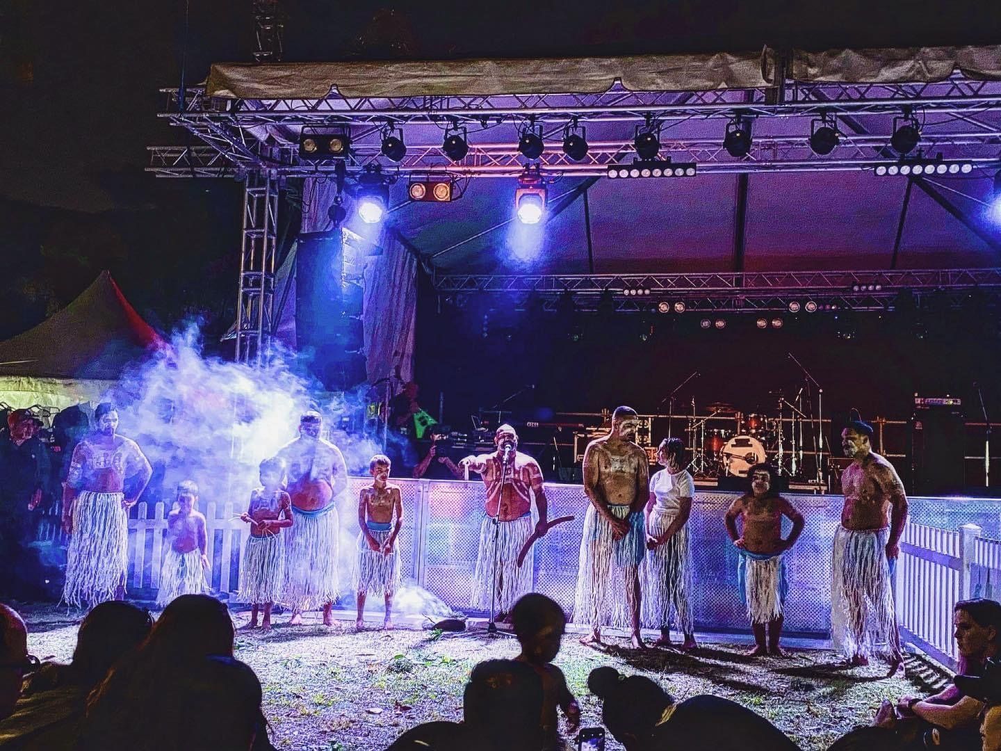 A group of people are standing on a stage in front of a crowd.