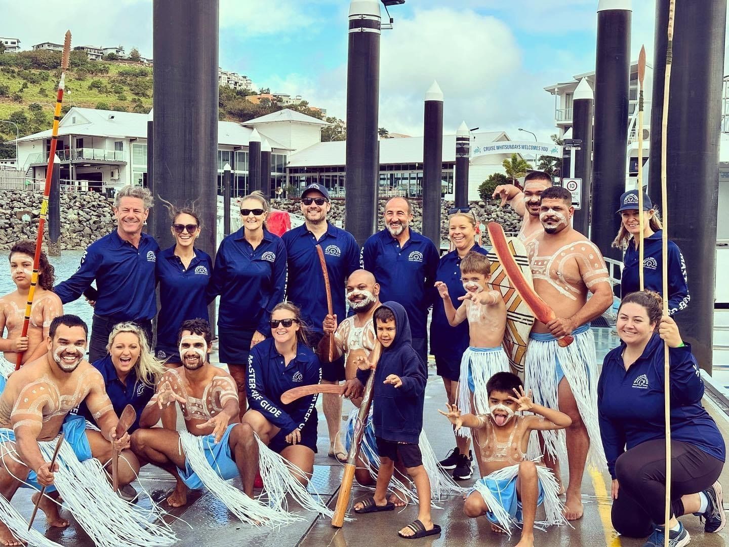 A group of people are posing for a picture in front of a dock.
