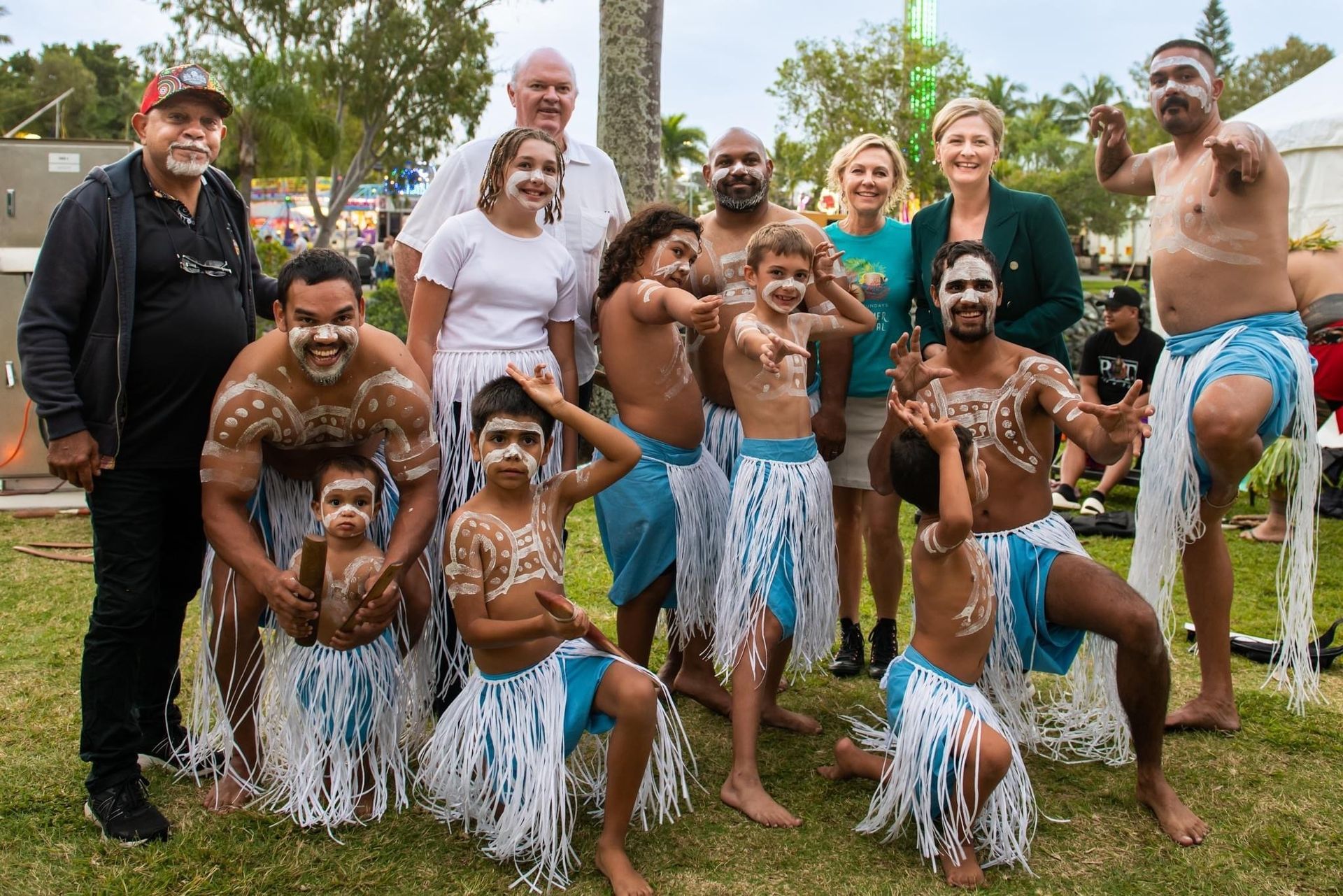 A group of people are posing for a picture in a park.