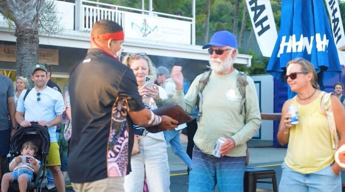 A man wearing a headband is talking to a group of people.