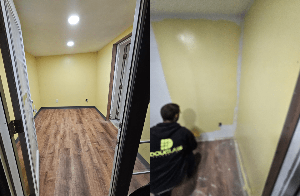 Room interior with yellow walls, hardwood-style floors, and a person painting a wall.